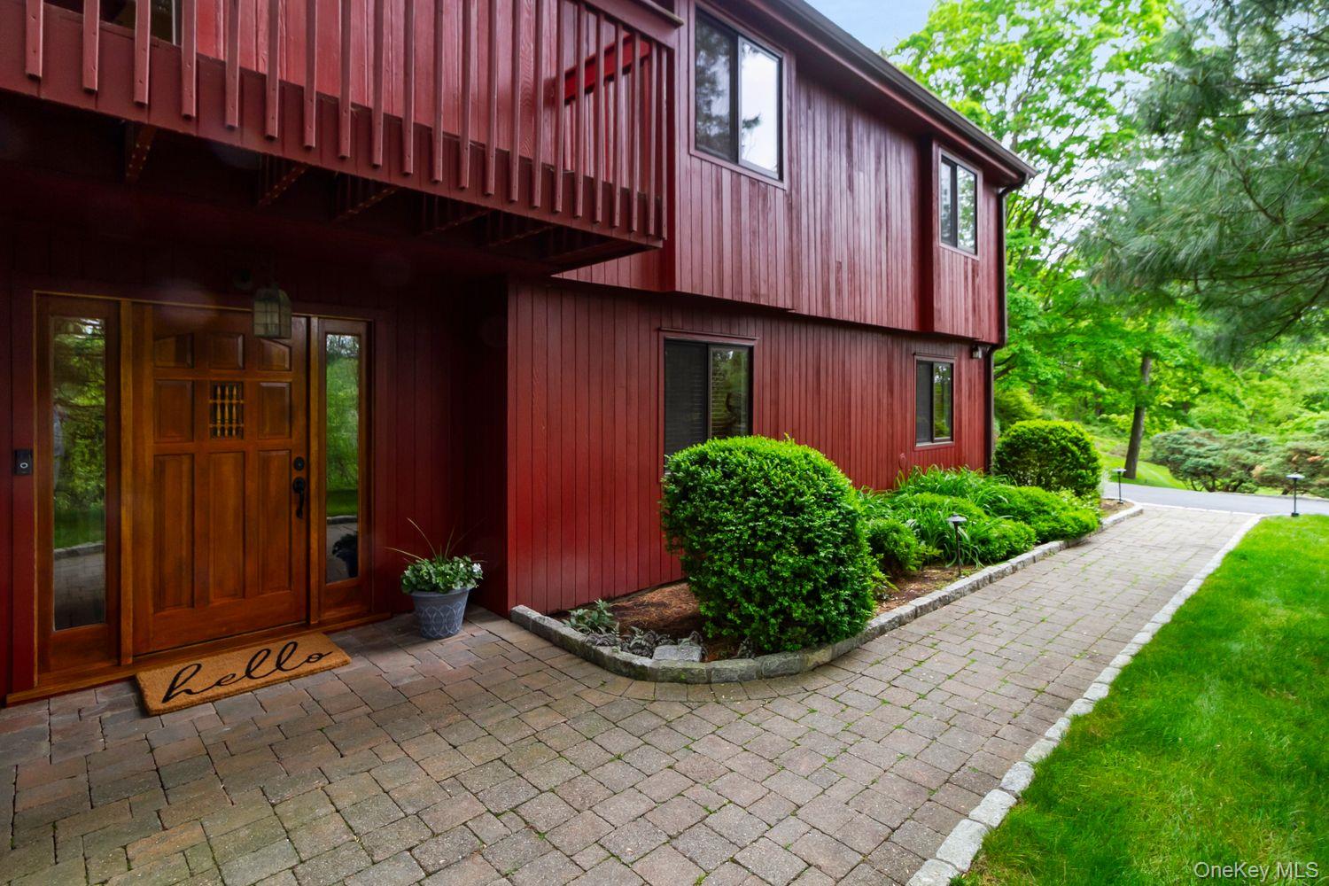 Tucked into a quiet cul-de-sac, yet in the center of everything, this meticulously maintained high ranch offers the warm, woodsy elegance of a Vermont retreat with a Westchester lifestyle. Filled with natural light, the home offers two comfortable levels with flexible spaces for everyday living and entertaining.

Upstairs, the formal living room with fireplace flows into sun-filled spaces accented by skylights and verdant views. The well-proportioned layout includes three bedrooms on the main level, including a primary suite. The lower level features a spacious second living area with built ins and a fireplace, perfect for a rec room, library, playroom and more. There is also a flexible fourth bedroom which is currently being used as a home office, a half bath, and convenient access to the attached two-car garage. A heated driveway takes the worry out of winter ice.

Located just minutes from tennis courts, a golf course, shops, restaurants and schools, with a quick drive to the North White Plains Metro-North station, this is a rare blend of rustic charm and commuter convenience, perfect for those seeking a peaceful retreat without leaving city life behind.