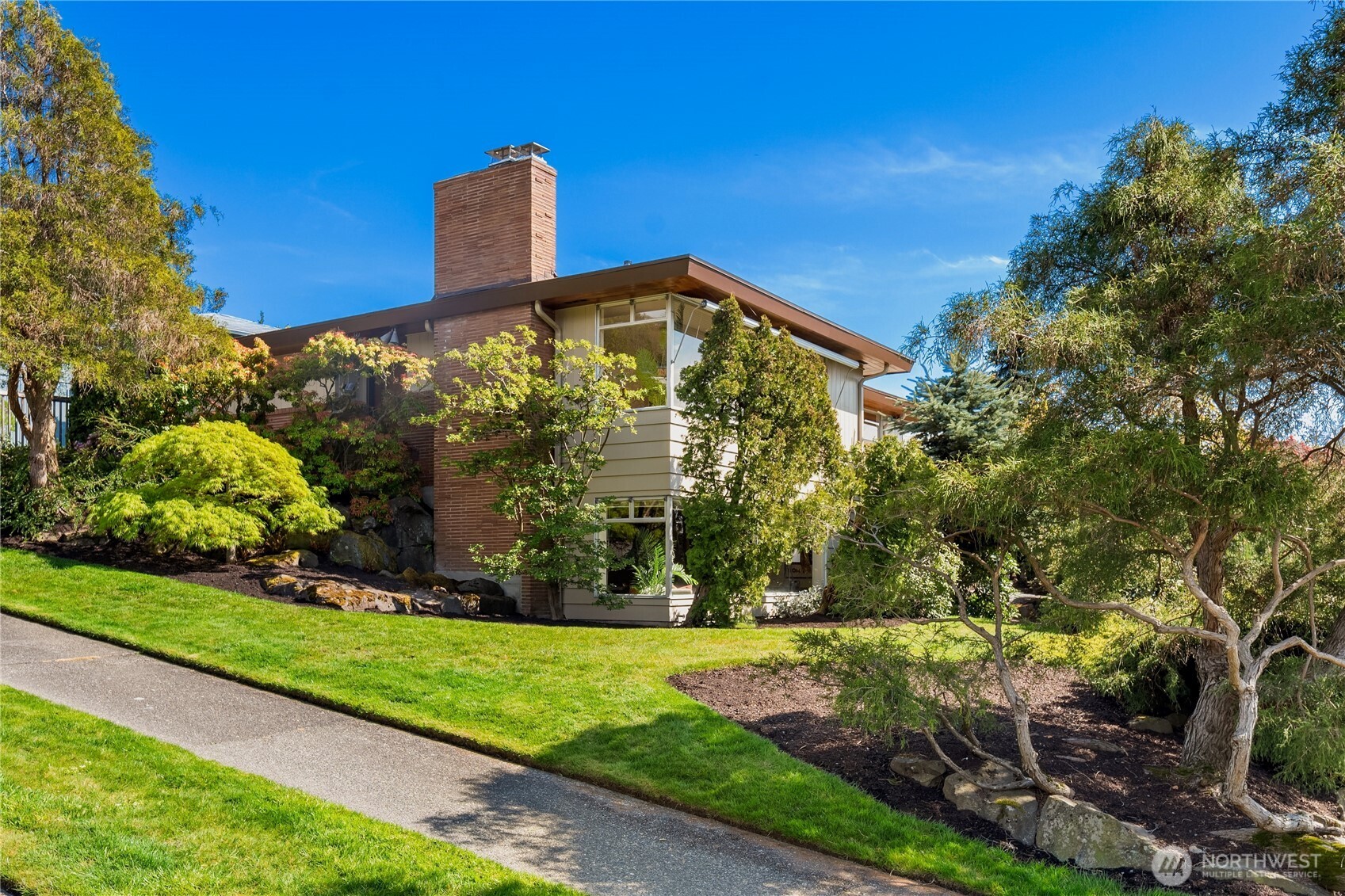 Hard to find and easy to love, this first-time-on-market Fauntlee Hills home blends classic charm with fresh updates in a coveted setting. Refinished oak hardwoods and abundant natural light create a warm, welcoming feel throughout, while the vintage kitchen and bathrooms offer a touch of classic charm. The main level features three bedrooms, a dedicated dining space and a cozy wood-burning fireplace. Enjoy peek Puget Sound and Olympic Mountain views, while new interior and exterior paint and refreshed landscaping enhance the home’s crisp, inviting presence. Large lower level showcases a wonderful family room, expansive bonus/utility room ready to adapt to your needs and full bath. The private patio provides the perfect outdoor escape, and the attached two-car garage with additional storage adds everyday ease. A rare opportunity to own a well-loved home with enduring character, thoughtful updates, and a location that truly shines.