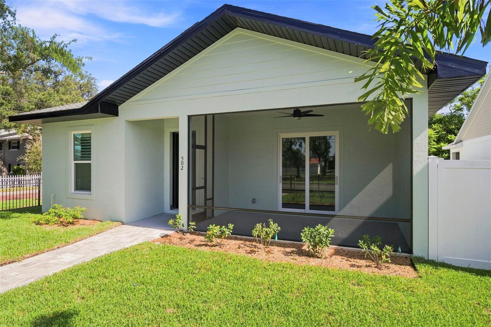 New construction home in downtown Dunedin. Completed in 2026 on a desirable corner lot on a brick-lined street across the street from the ballpark. Features a split plan with two large guest bedrooms and generous bathroom. Primary suite includes large walk-in closet with his-n-her sides. Primary bath has curbless shower with French doors, dual sinks and generous storage. Kitchen includes GE appliances, a beverage fridge, farmhouse sink, soft close cabinets, and ample storage on large island. Great room has tray ceiling and floor outlets for maximum flexibility. Laundry room includes a sink and full complement of cabinets. Other features include a den; screened front porch; plantation shutters; privacy screen for oversized slider; engineered hardwood floors throughout; tankless gas water heater; and granite countertops. Large two car garage with off-street parking for golf cart. Exterior includes flowering plants, palm trees and oak trees with irrigation system on reclaimed water. Front yard includes sod with low maintenance mulch on back and side yards. Includes builder’s warranty.