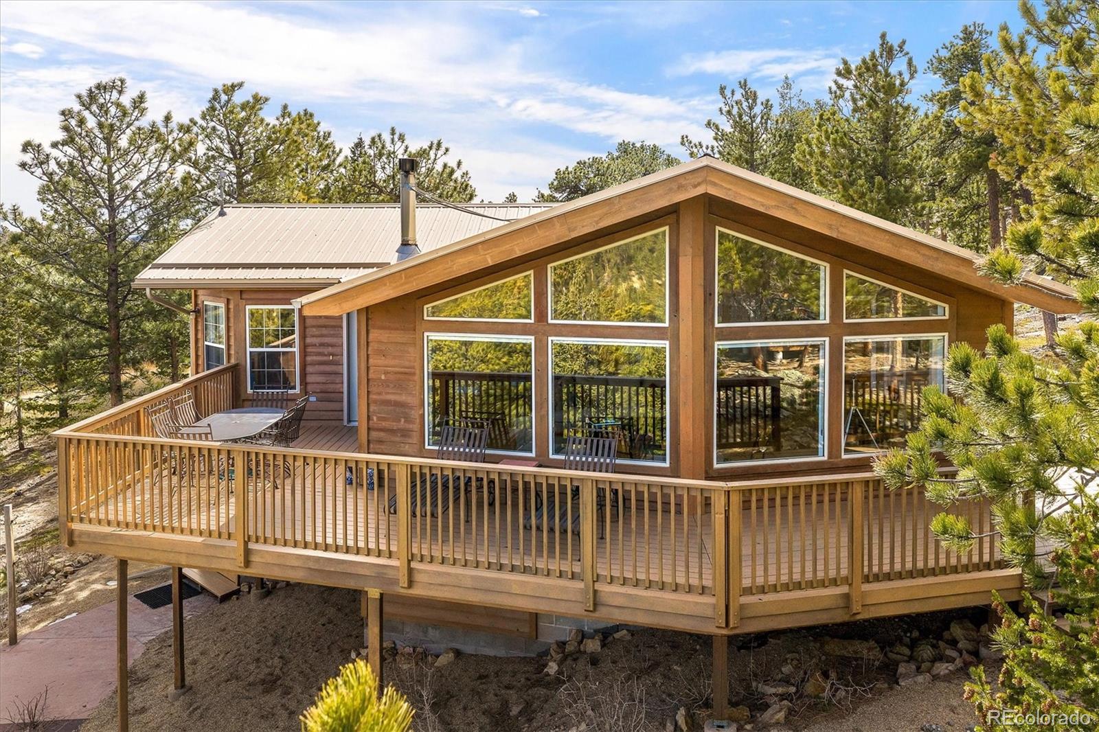 Marvel in the journey via the historic and picturesque Peak to Peak Scenic Byway or the breathtaking St.Vrain Canyon that leads you to the sweeping, unobstructed views of the Continental Divide. The iconic Mount Meeker view is captured from this turnkey mountain retreat perched in the serene foothills of Rockledge Park. Immaculately maintained, this residence is defined by lofty vaulted ceilings and a light-filled open floor plan, where dramatic floor-to-ceiling windows frame snow-capped peaks and ever-changing skies. A wraparound deck extends the living space outdoors, offering an extraordinary setting for entertaining or quiet moments immersed in nature. Rich alder wood doors and hickory hardwood floors add warmth and refinement, while a cozy Hearth Stone wood burning stove anchors the living area. Updated features include: a new state of the art whole house boiler by Weil-McLein, a new GE dishwasher, newly finished and sealed deck interior and exterior, freshly painted, well maintained forest land including mitigation in compliance with insurance regulations, and the list goes on. A lower walkout level includes a separate entrance with a roomy recreational setting featuring a pool table/TV, bedroom and 3/4 bath. When exploring the outdoors this property set on a nearly 6 acre lot that offers the freedom to roam the bordering National Forest, inviting endless adventuring right from the backyard, and includes a charming mini cabin with inspiring views. Set among gentle terrain and striking rock outcroppings, this peaceful sanctuary offers abundant wildlife sightings and sounds, unmatched privacy and convenient access to nearby townshipse. Nearby destination points include Allenspark, Ferncliff, Lyons, Boulder, and the entrances to Wild Basin region of Rocky Mountain National Park with ease of access to Longs Peak and Mt. Meeker.