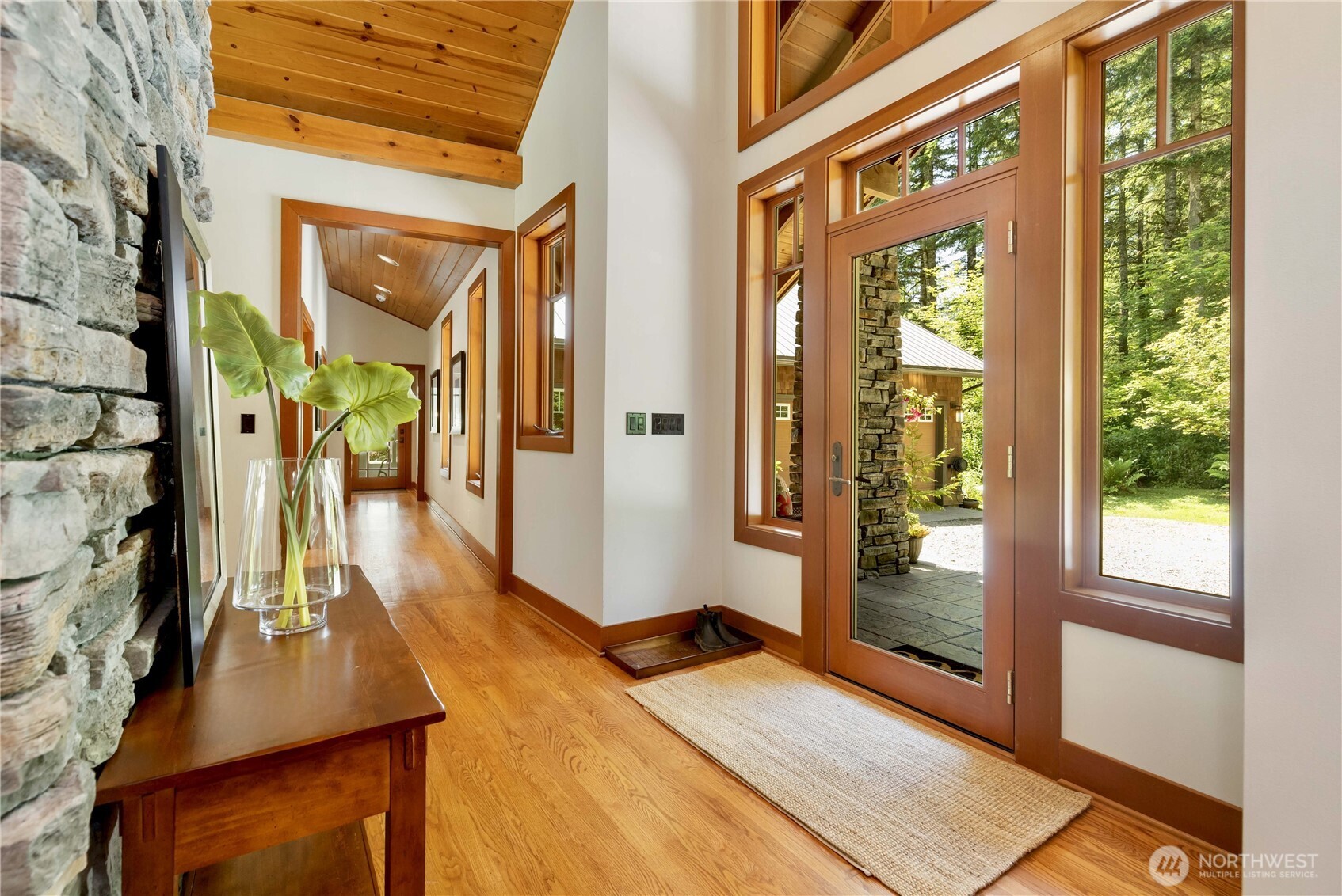 Escape to this incredible custom Craftsman woodland retreat, an exquisite lodge-style rambler designed for tranquility, adventure & timeless beauty! Set amidst nature, this finely built home showcases rich hardwoods, slate accents, a striking stone fireplace, soaring wood-lined cathedral ceilings & wrapped windows. The open-concept layout features a serene master suite, private guest suite, elegant library, mudroom & spacious 500 sq ft bdrm/bonus/bunk room. Enjoy year-round comfort w/ radiant heat, solar hot water, central vac & security system. The 1200 SF atrium w/ solar-heated pool, bath & laundry completes this rare sanctuary, just 6 miles from amenities! Deep 2-car garage has ample room for workspace, tools or toys! PRE-INSPECTED!