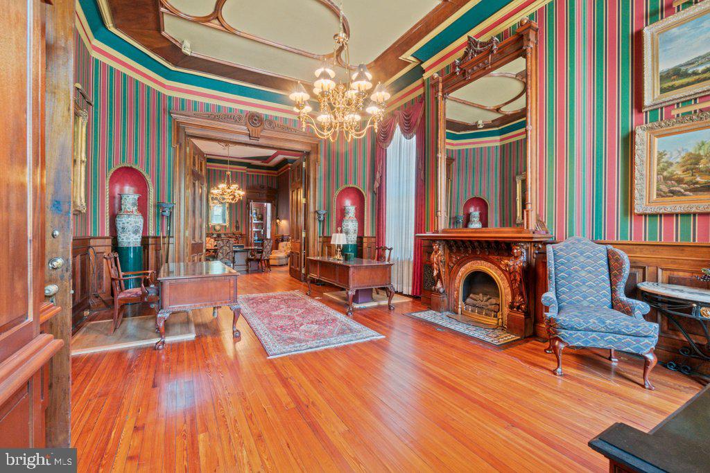 The crown jewel of the building, Unit 15 is a parlor-level suite of extraordinary scale and craftsmanship. Soaring 15' ceilings, monumental 9' entry doors, and intricately carved wooden mantels establish a remarkable sense of presence from the moment you arrive. The double parlors are distinguished by burl wood doors and paneling rising to the chair rail, restored in the mid-1990s when the current owner painstakingly stripped decades of shellac to reveal their natural glow.Light pours through two 11' east-facing windows overlooking Saint Paul Street and additional 9' north-facing windows along Biddle Street, framing the suite with dramatic exposures. At its center, a set of monumental burl-wood double doors — each 11' tall and 4'5" wide, spanning nearly 9' across — divide the rooms with theatrical presence.Unit 15’s cinematic elegance even drew Hollywood: scenes from The Accidental Tourist starring Geena Davis, William Hurt, and Kathleen Turner were filmed here. Today, the suite includes a kitchenette and full bath, requiring only the addition of a range or cooktop to be fully residential. With its combination of scale, materials, and provenance, Unit 15 stands as a one-of-a-kind opportunity in Mount Vernon.The History: History: At the heart of Mount Vernon, 1118 and 1120 Saint Paul Street embody Baltimore’s architectural legacy. Designed and once occupied by George A. Frederick — the young prodigy behind Baltimore City Hall and the city’s park system — these brownstones reflect both history and craftsmanship. Now ,for sale within them are five distinct condominium units: dramatic parlor-level suites with soaring ceilings and ornate detail, alongside expansive lower-level spaces with flexible layouts and private entries. Together, they offer owner-users a rare mix of historic pedigree and practical adaptability in Baltimore’s cultural core.Contiguous space available.