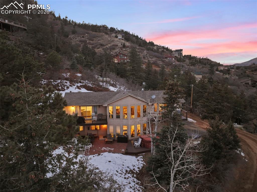 The perfect balance of peaceful mountain living and everyday convenience in the exclusive, private gated community of Crystal Park. Ideally located just minutes from the charm of downtown Manitou Springs and the amenities of Colorado Springs, this beautifully maintained home offers a rare opportunity to enjoy a serene retreat without sacrificing accessibility. Tucked into a quiet, desirable setting in lower Crystal Park, this property is surrounded by natural beauty and provides an atmosphere of privacy, tranquility, and breathtaking scenery. From the moment you arrive, you’ll appreciate the calm mountain environment, where fresh air, towering pines, and stunning vistas create an unmatched sense of escape. Step outside onto one of two expansive composite decks or the inviting patio and take in sweeping views of the surrounding mountainside along with sparkling city lights in the evening. The heart of the home has been beautifully updated with a completely remodeled kitchen and dining room, enhancing both style and functionality. These refreshed spaces are perfect for gathering, cooking, and entertaining while enjoying the open flow of the main living area. Extensive windows fill the home with natural light, while the main level offers an inviting great room centered around a cozy gas fireplace, providing a warm and welcoming space to unwind. Also located on the main floor, the primary suite serves as a peaceful retreat with a luxurious, adjoining five-piece bath that has been thoughtfully updated with in-floor heating for a spa-inspired experience and year-round comfort.  Lower level expands the home’s versatility, featuring a spacious family room with a private entrance and access to the patio—perfect for guests, additional living space, or multi-generational flexibility. Two additional bedrooms and a full bathroom are also located on this level, providing plenty of room for visitors, family, or a home office setup.