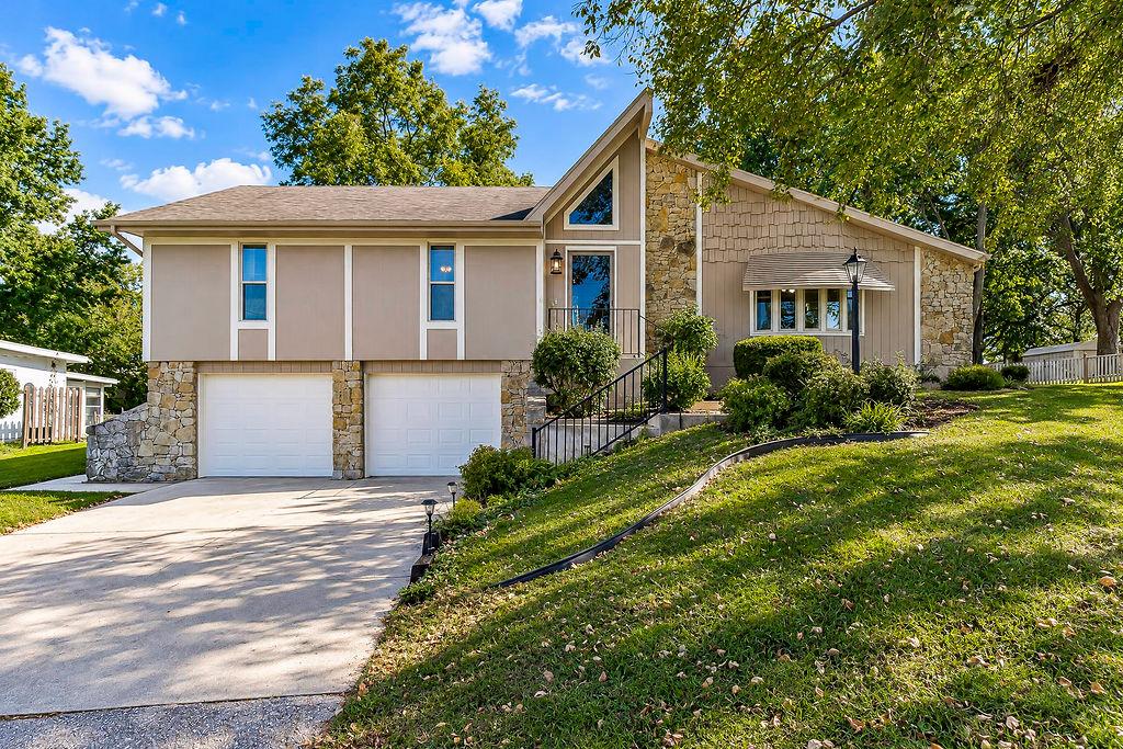 Step into this well-maintained raised ranch, perfectly positioned on a double lot in Lake Lotawana. The enclosed foyer offers a welcoming transition from the outdoors and protection from the elements before opening into a spacious living room with vaulted ceilings and a striking stone fireplace.The kitchen features abundant cabinetry and flows into a bright sunroom—an ideal space for a home office, sitting room, or second living area. Just beyond, the screened-in porch overlooks a peaceful backyard with no immediate neighbors behind, along with beautiful lake views.The spacious primary suite includes a private bath, while two additional generously sized bedrooms and a full hall bath complete the main level.Downstairs, you’ll find a second living area with another fireplace, a full bath, and a large storage room. The oversized two-car garage offers even more storage, and the garage doors are only a few years old. A flat driveway and generous storage are rare finds at Lake Lotawana.Outside, the home has been thoughtfully maintained over the years, including James Hardie siding and fresh exterior paint in 2026.Enjoy access to a swim dock just across the street in coveted Bandit Bay—a large, spacious cove with deep water, easy boat parking, and plenty of room to spend lake days with neighbors and friends.Lake Lotawana offers a lifestyle unlike anywhere else in the Kansas City area. Boat over to Kansas City’s only waterfront restaurant accessible by water, or head just minutes away to the community park, tennis courts, numerous local restaurants, brewery and coffee shop. From fishing tournaments and water skiing to sailing, kayaking, and year-round community events, there’s always something happening in this one-of-a-kind lake community.