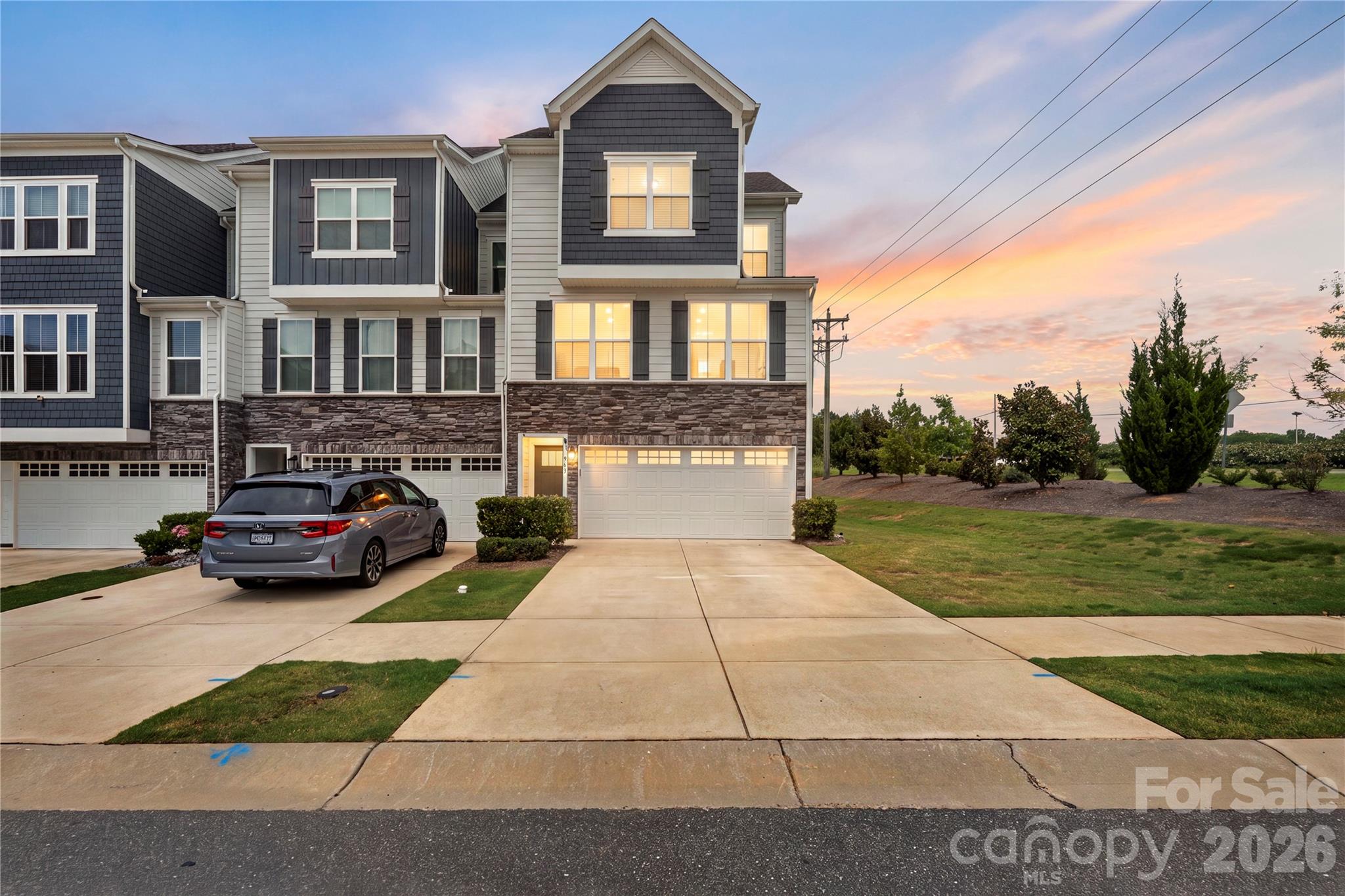 Stunning Move In Ready end-unit 3-story townhouse built in 2021 offering 4 bedrooms, 3.5 bathrooms, and over 2,200 square feet of beautifully designed and updated living space. Ideally situated on a corner lot at the end of a cul-de-sac, this home offers added privacy and a peaceful surround; perfect for indoor or outdoor lifestyles. The main level features a private bedroom with a full bath, perfect for guests, multi-generational living or a secluded home office. The second floor showcases an open-concept living area with luxury vinyl plank flooring, a spacious and bright living room, dining area, and a modern kitchen complete with a large island with bar seating, tile backsplash, quartz counters, and Energy Star appliances. You will love the covered porch off of the main level featuring a gas fireplace insert and retractable screens making this the perfect space year-round! Upstairs, the luxurious primary suite in complete with Tray ceilings, walk in closet with shelving system, and ensuite bath with dual vanity and tile surround shower! The two additional generously sized bedrooms offer great flex spaces or additional living space if needed and finally the laundry area is situated on the upper level for convenience. Additional highlights include a 2-car garage, drop zone, fiber internet availability, and low-maintenance living with lawn care included. Convenient location just minutes from Tega Cay, Fort Mill and provides easy access to I77 and 485 loops!