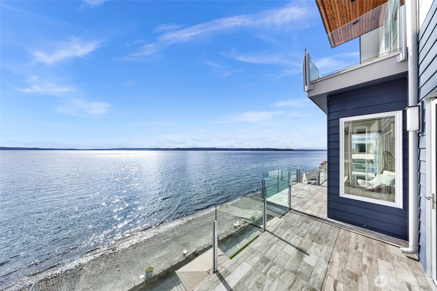 Discover unparalleled luxury in this stunning 2019 waterfront masterpiece in exclusive Shorewood on the Sound. This magnificent gated estate boasts 62 feet of pristine low-bank shoreline with boat ramp and breathtaking Puget Sound vistas. Seamlessly blending sophisticated indoor-outdoor living via NanaWall systems, the open design showcases a chef's kitchen with premium Bluestar range, dual dishwashers, and double sinks. Luxurious amenities include heated bathroom floors, soundproofed bedrooms/office, individual climate controls, and elevator-ready design. The extended-height garage accommodates two cars with EV charging, plus 2,000+ sq ft storage. Experience refined coastal elegance in this rare 12-home enclave.