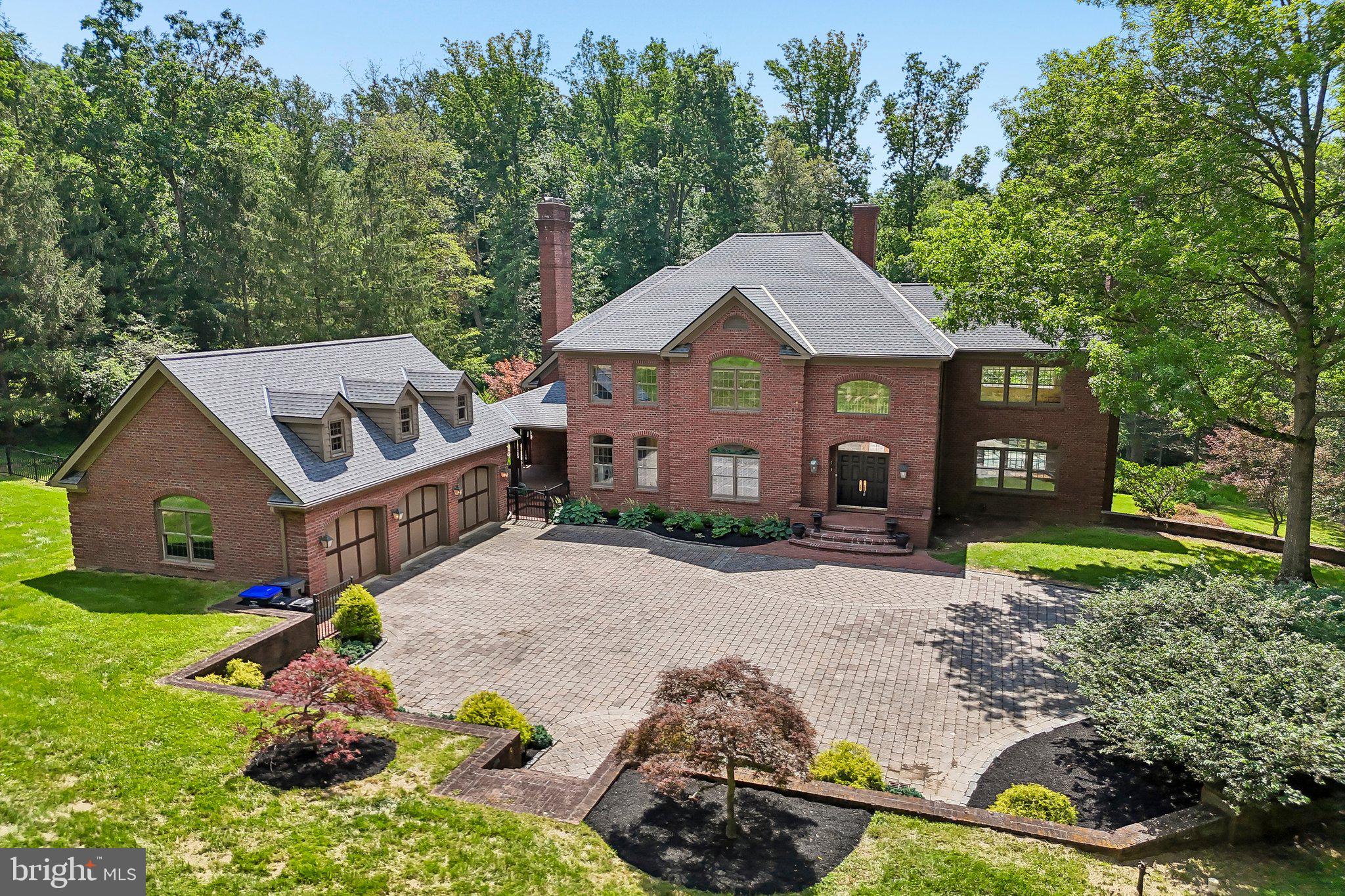 Tucked beyond a gated entrance and approached by a picturesque, tree-lined drive, this custom home offers an exceptional blend of timeless architecture, impeccable craftsmanship, and resort-inspired living on beautifully landscaped, private grounds. Featuring 5 bedrooms and 4.2 bathrooms, this remarkable residence located within top rated Great Valley Schools is thoughtfully designed for both grand-scale entertaining and comfortable, everyday living. A dramatic two-story foyer with a sweeping dual staircase welcomes you into rich hardwood flooring, intricate millwork, custom built-ins, and walls of windows that fill the home with natural light. The richly appointed office with fireplace and custom cabinetry offers the perfect work from home space. The elegant living room with a gas fireplace and attached solarium over looks the rear yard while the formal dining room offers a great space for your intimate  gatherings. From here, the gourmet kitchen features a center island, professional-grade appliances, custom cabinetry, a walk-in pantry, butler's pantry, and a sun-filled breakfast room. Transitioning from the kitchen, the family room offers a gas fireplace, floor-to-ceiling windows, and a built-in entertainment wall. The first level is completed with a laundry room, 2 powder rooms, and a mudroom. The second level offers a luxurious primary suite with a fireplace, tray ceiling, spa-inspired bathroom, and a walk-in closet with built-ins. Three spacious additional bedrooms, one with its own private bathroom and a shared hall bathroom, complete this level. The semi-finished third level with cedar closet is perfect for storage while the expansive walk-out lower level offers endless flexibility with two spacious recreation rooms, a wood burning fireplace, a wet bar, full bathroom, and multiple bonus spaces perfect for a home theater, gym, guest suite, or additional office. The lower level was previously an in-law suite.Outside, this property is every bit as impressive. Expansive decks, flagstone terraces, professionally designed gardens, and a salt-water pool offer an extraordinary setting for entertaining and relaxation. A detached three-car garage with second story, offers storage or future finished living space, completing this one-of-a-kind estate. This amazing property is close to major roadways for an easy commute and to the shopping and dining options of Malvern, Ellis Preserve, Wayne and West Chester and minutes to the some of the best private academies in the country. Call today for more information; this property is not to be missed!