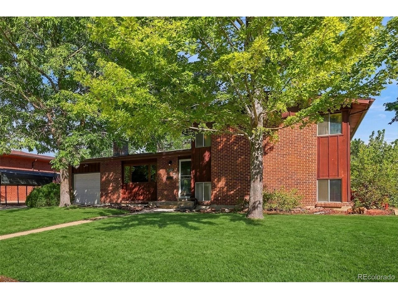 ***OPEN HOUSE SEPTEMBER 19, 10-1PM! Beautifully maintained brick tri-level nestled on a super quiet street in Arvada's highly desirable Allendale neighborhood! This timeless home blends classic mid-century modern character with a warm, inviting floor plan featuring 4 bedrooms, 2 bathrooms, real hardwood floors, soaring vaulted ceilings, skylights, and abundant natural light throughout. The spacious eat-in kitchen opens to comfortable living spaces, while the finished basement offers the perfect place to unwind beside the impressive floor-to-ceiling rock fireplace. A charming three-season room overlooks the beautifully landscaped backyard, creating an ideal space to enjoy your morning coffee or set up a studio, plant room or den. Step outside to a large, private yard complete with a spacious patio, deck, mature trees, and a storage shed, perfect for entertaining or simply enjoying Colorado's beautiful seasons. The oversized attached one-car garage, detached covered carport, and generous off-street parking provide exceptional flexibility for vehicles, hobbies, or recreational toys. Ideally located just minutes from parks, schools, shopping, Olde Town Arvada, and with convenient access to Denver, Boulder, and the mountains, this is a rare opportunity to own a lovingly cared-for home in one of Arvada's most established and sought-after neighborhoods.