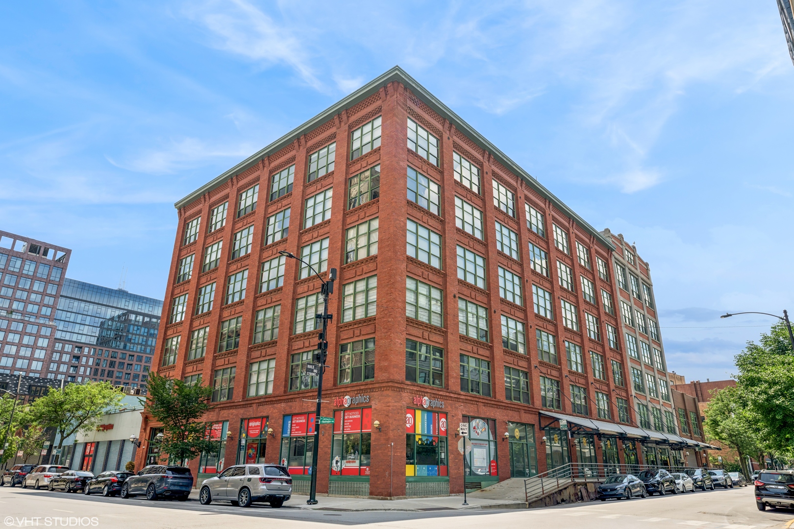 Soaring ceilings, sunlit spaces, and sleek finishes define this top-floor unit in the classic Acorn Lofts in the vibrant West Loop. Beautifully renovated, this brick and timber loft offers incredible natural light from its western exposure. The open-concept layout showcases 4" oak tongue-and-groove hardwood floors throughout and a striking chef's kitchen centered around a large island. Features include quartz countertops, a subway tile backsplash, open shelving, and custom all-wood cabinets with dovetail-joint drawers in a walnut-grey finish. Premium appliances include a Thermador 6-burner range, Samsung refrigerator, stainless hood, microwave drawer, and Thermador dishwasher. A wood-burning fireplace with a quartz hearth adds warmth and character to the living space. Both bedrooms are fully enclosed for privacy, including a serene primary suite with sliding wood doors and walk-in closet. Bathrooms feature custom cabinetry with ample storage. A spacious laundry/storage room adds everyday convenience. The sellers are also open to selling the home furnished, making this a truly move-in-ready opportunity. Deeded parking space (#46) available for $25k.