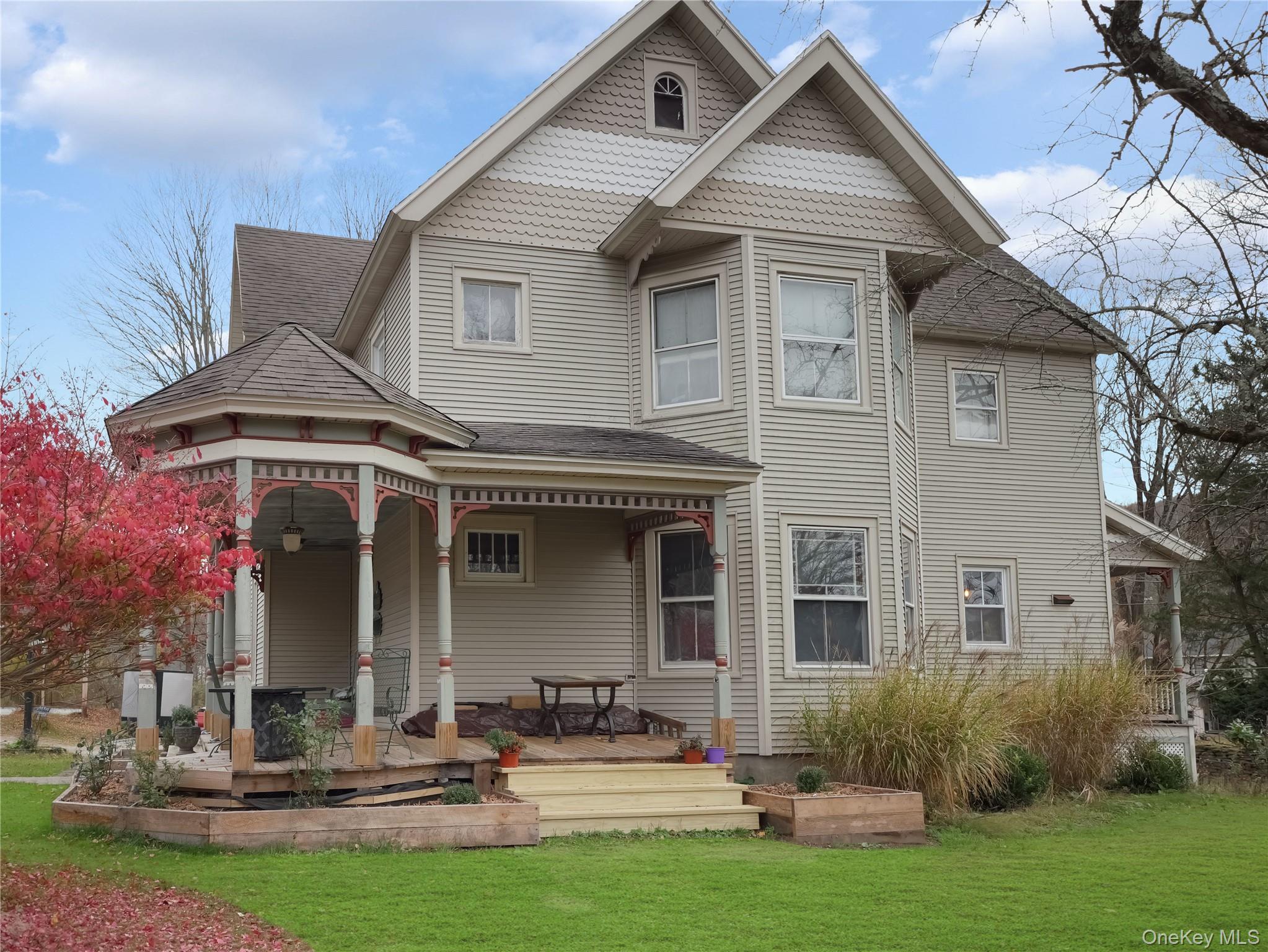 Back of property with roof with shingles, a lawn, and covered porch