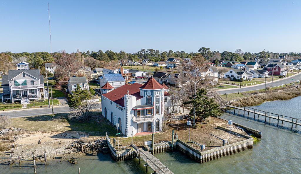 Someone dreaming of a castle on a beautiful island by the sea? Here's your opportunity with this unique waterfront Castle home on Chincoteague Island.  3 Bedrooms, 1.5 baths & 2 waterfront exterior balconies with views everywhere.  Long lite pier on the Chincoteague Channel offers great opportunity for fishing and crabbing off your own pier or enjoy the beautiful lighted pier & serenity. From the built in bench on the dock you have a front row seat to the Rocket Launches and dolphins at play in the Chincoteague Bay. Great location only blocks from Carnival Grounds or Town of Chincoteague.  When you invite friends and family over they are sure to find you, This home stands out from the crowd.  Have a home that's as unique as you are.  Garage area underneath/with storage and elevator.