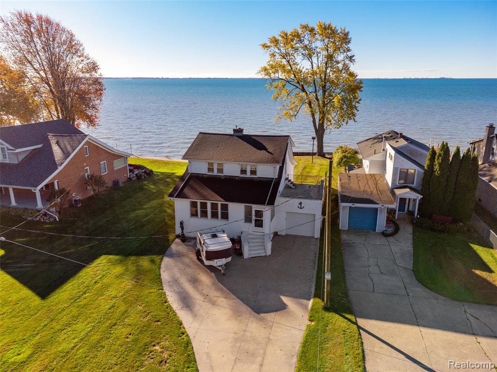 Experience the best of lakefront living in this beautifully maintained three-bedroom, two-bath home with sweeping views of Anchor Bay. Wake up to stunning sunrises and unwind with peaceful evenings along the water’s edge. This home offers three inviting living spaces, including a cozy living room with a classic brick fireplace—perfect for relaxing or entertaining. Rich wood floors flow throughout, complemented by a bright kitchen with generous storage and workspace. The partial basement, is plumbed/set up for an additional half bath. Enjoy the spacious yard and seawall just steps from the lake, ideal for boating, fishing, or simply soaking in the views. Complete with a one-car attached garage, wide driveway, and timeless coastal appeal, this home offers comfort, character, and an enviable Lake St. Clair lifestyle.