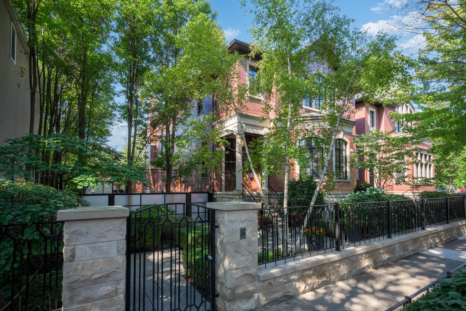 Welcome to 3752 N. Janssen, an extraordinary residence set on a rare 62.5' x 125' lot in the heart of the Southport Corridor. The home itself sits on a 37.5'-wide lot, while the adjoining 25' x 125' landscaped side lot has been transformed into a private outdoor sanctuary. Hidden discreetly behind a privacy wall, this urban oasis features lush gardens, a tranquil water wall, a bluestone patio with built-in firepit, a sport court, and a garage roof deck-all enhanced with integrated surround sound for seamless indoor-outdoor living. A rare 3-car heated and attached garage offers effortless convenience and comfort, elevating everyday living in this remarkable city retreat. With 5 bedrooms, 4.3 baths, and 6200 SQFT of living space, this home is truly a forever home. A refined marble-floored entry opens into a dramatic two-story foyer with a curved staircase, custom millwork, coffered ceilings, and a Dennis & Leen light fixture instantly setting the tone for the elegance that defines this home. The living room exudes quiet sophistication with silk wall coverings, coffered ceilings, a gas fireplace with stone mantel, and a bay window overlooking tree-lined Janssen Street. The formal dining room, anchored by a striking David Iatesta chandelier, is enveloped in custom millwork and hand painted wallpaper with hand embroidered silk cherry blossoms, framed by antique mirrored shelving that elevates the ambiance for refined entertaining. A butler's pantry connects the dining room to the kitchen, offering granite counters, a beverage cooler, ample storage, and a walk-in pantry.  The width of this home is evident in the kitchen and family room and maintains the same elevated aesthetic. The kitchen showcases 2-inch granite counters, abundant 42" cabinetry, professional-grade Wolf, Miele, and Sub-Zero appliances, dual sinks, and an oversized island with breakfast bar. A bright breakfast nook fills the space with natural light. The adjoining family room features custom built-ins, a limestone-surround fireplace and French doors opening to a charming terrace ideal for morning coffee or evening cocktails. Steps lead down to the landscaped backyard oasis and a roof deck above the three-car garage. A stylish powder room completes the main level. Ascending the curved staircase, four exceptional bedrooms await. The primary suite - an elegant retreat - offers vaulted ceilings, silk wall coverings, custom moldings, luxe silk draperies, hardwood floors and a custom walk-in closet with fine wood-built ins. The spa-caliber bath includes heated stone flooring, a double steam shower, jetted tub, Duravit double vanity, limestone counters, and a private commode. The second bedroom includes an ensuite bath, while the third and fourth share a Jack-and-Jill with walk-in closets. A laundry room with Whirlpool appliances, granite counters, and 42" cabinetry completes this level. The third floor, currently configured as a spacious home office, features vaulted ceilings, skylights, hardwood floors, and a powder room. The fully finished lower level offers soaring ceilings and versatile living areas, including a recreation room large enough for gaming, media, and entertaining with a full wet bar, beverage center, and custom built-ins. A mirrored home gym with ballet bar, a guest suite with ensuite bath, a 250+ bottle temperature-controlled wine cellar, a craft room, powder room, mudroom, and abundant storage complete this level. For the car lovers, the attached 3-car garage offers room for your favorite cars or provides additional storage. Perfectly positioned in the Southport Corridor, this remarkable home is located within the highly regarded Blaine Elementary School district. Welcome home to 3752 N. Janssen, where elegance meets everyday comfort in one of Chicago's most coveted neighborhoods.