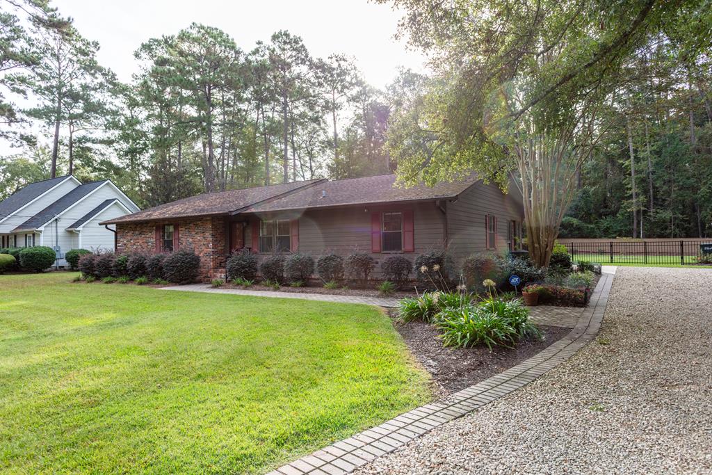 One of Thomasville's most desirable established in-town locations! This brick and cedar siding ranch home is located in the heart of the city, nestled in a beautiful setting of live oaks and manicured lawns, just a short walk or cart ride to downtown, recreation, city and county schools, and shopping. No stairs to enter and all living space on one main level, makes this a great home for accessibility. Approximately 1,909 Sq. Ft,  3 bedrooms, 2 full baths, formal living room, dining room,  kitchen with stainless steal appliances, double ovens, granite counter tops,  with a bar area that opens to a large traditional family room. Additional bonus room can be used as an extra bedroom, office, or gym. Massive lodge style screened back porch overlooks perfectly maintained professionally landscaped back yard with recently added privacy fencing and irrigation system. While outside, enjoy the spacious back yard and sizable, electrified hobby house that can also be used for storage. Main house has Generac generator. Don't miss this rare opportunity to live in one of the most convenient and scenic locations around!