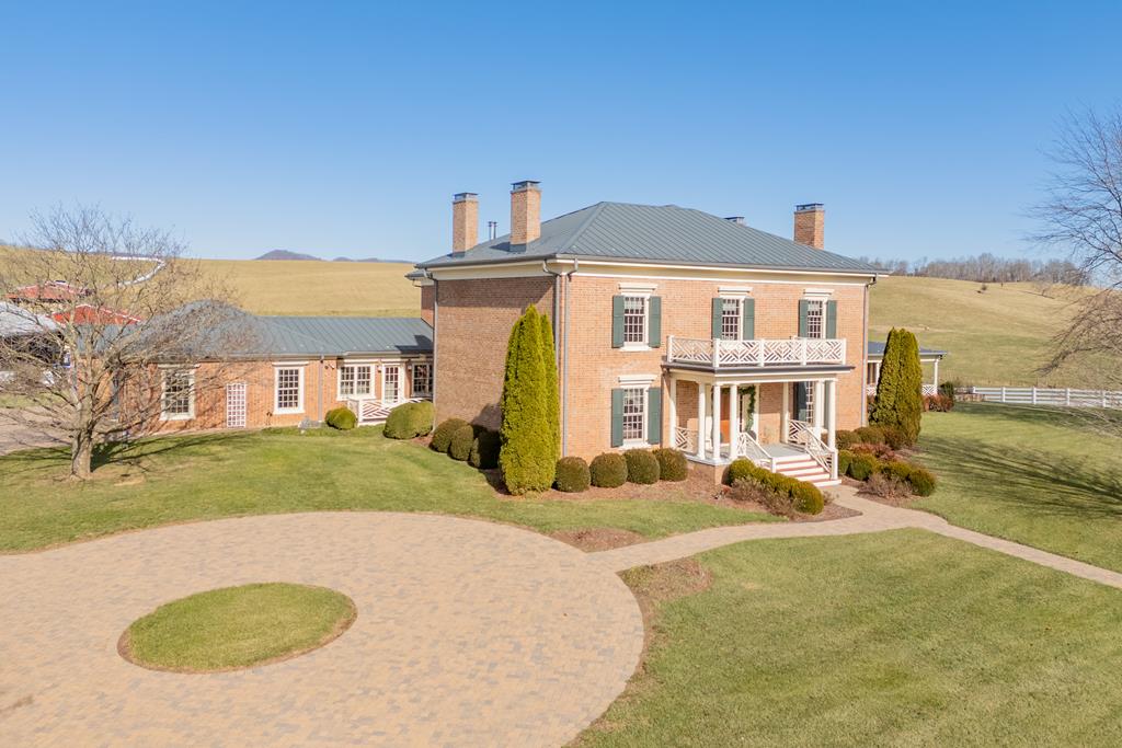 Historic 1845 Traditional/Federal Estate  Nearly 8,000 Sq Ft  Modern Luxury Crafted to Match 19th-Century Charm.  Step into a rare blend of historic character and sophisticated modern craftsmanship in this Traditional/Federal-style estate, originally built in 1845 and thoughtfully expanded in 2009–2010. Every addition was meticulously designed to mirror the home's original architectural details, resulting in a seamless integration of old-world charm and contemporary comfort across nearly 8,000 square feet of living space. Offering 5 bedrooms and 5 full bathrooms, the home provides exceptional flexibility for families, guests, and long-term visitors. A complete mother-in-law suite adds valuable independent living space with privacy and comfort, ideal for multigenerational living, extended stays, or premium guest accommodations. Inside, 10-foot ceilings and ten fireplaces with gas logs create a warm, inviting atmosphere throughout. Light flows through insulated windows fitted with plantation shutters, enhancing beauty and energy efficiency. Modern systems include geothermal heating and cooling, a standing seam metal roof, and a whole-home propane generator, ensuring lasting comfort and reliability. A wide driveway crafted from durable concrete pavers leads to the three-car garage, while a white vinyl fenced yard and mature trees frame the property with timeless curb appeal. Outdoor living is equally impressive, with beautiful views from the balcony and deck, offering peaceful spaces to relax or entertain while overlooking the surrounding landscape. This extraordinary estate combines the grace of its 19th-century origins with the convenience and performance of modern systems—an exceptional opportunity for those seeking history, scale, and refined living in one remarkable home.