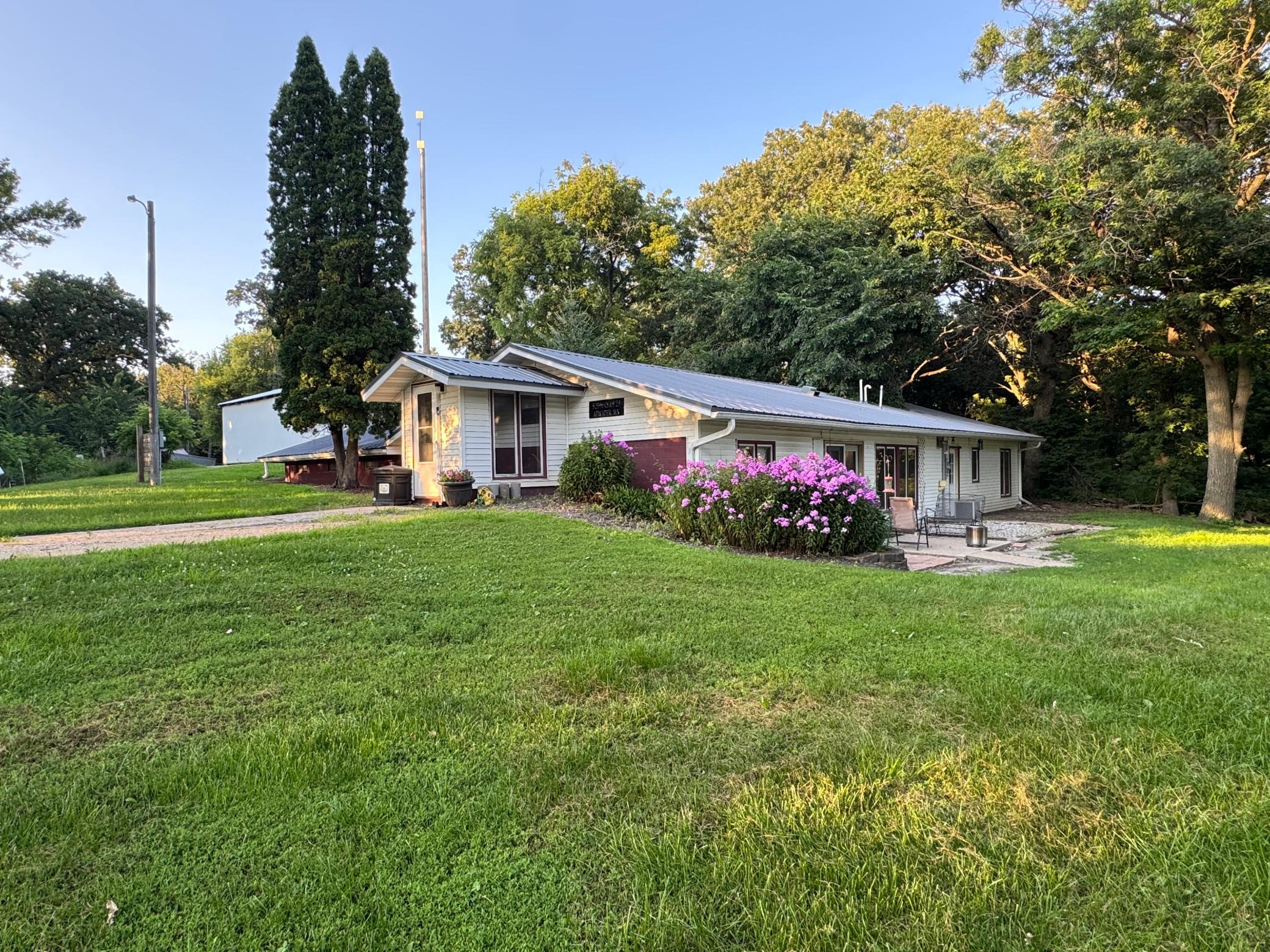 Situated on 10 acres, this country property offers a versatile combination of hobby farm amenities, wooded acreage, and convenient one-level living. The livestock area is equipped for immediate use with freestanding cattle gates, a gravity feeder, and three water hydrants. Outbuildings include a 30x50 open stall barn/animal shelter, a 16x18 shop/garage, a 25x60 pole shed, a chicken coop, and a dog kennel. Approximately six wooded acres with a pond offer hunting and recreation opportunities, with potential for additional pasture.The home features three bedrooms and one bathroom, plus additional unfinished square footage that could accommodate another bedroom and bathroom. Updates include a newer furnace with a smart thermostat, a tankless water heater, a water softener, and a water filtration system. With established animal facilities and a blend of open and wooded land, this property offers a variety of possibilities for rural living.