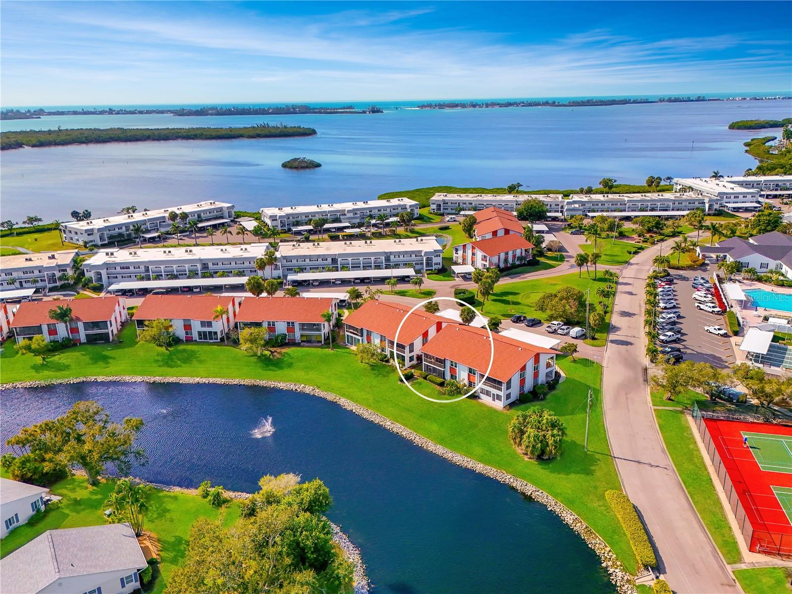 WELCOME TO THIS EXCEPTIONAL LAKEFRONT CORNER CONDO located in sought-after bay and canal-front community, where comfort, value, and resort-style living come together. This residence offers the largest two-bedroom floor plan and is thoughtfully upgraded to provide both everyday enjoyment and long-term peace of mind. MAJOR IMPROVEMENTS translate to lower insurance costs and add security- 2021 impact windows, 2020 HVAC system meticulously maintained, 2019 roof with 3rd nail in roof-to-wall connectors, and 2016 water heater with sensor. Plus, LOW-COST TRANSFERABLE FLOOD INSURANCE and INSURANCE CREDITS for affordable property insurance. These notable improvements make this home a standout choice for full-time residents, seasonal owners, or savvy investors. INSIDE AN OPEN & INVITING LAYOUT is enhanced by an abundance of natural light, porcelain tile floors, crown molding, solid wood cabinetry, custom window treatments, sunshades, upgraded fixtures, and storage galore. The thoughtfully designed floor plan places both large bedrooms and updated baths along a private hallway, offering separation and comfort for owners and guests alike. KITCHEN- The spacious kitchen blends style with functionality, featuring solid wood cabinetry with crown molding and under-cabinet trim, built-in organizational features, generous solid-surface counters, and a convenient breakfast bar perfect for casual dining or for a buffet when entertaining. Additional highlights include deep dual-bowl sinks, closet pantry, tray ceiling, and recessed lighting that creates a bright, welcoming space. DINE & LIVE- The dining and living room combination is filled with wonderful natural light and offers flexible furniture placement for both everyday living and entertaining. LANAI- Wall-to-wall sliders open to the tiled and screened lanai, where you can relax under the fan and take in tranquil lake and wildlife views, complemented by the soothing sound of the fountain. PRIMARY SUITE- Tucked away for privacy, the expansive suite overlooks the lake and features dual closets and a remodeled ensuite bath with dual-sink vanity, solid wood cabinetry, brushed nickel hardware, updated lighting, a private toilet alcove, and a newer tiled shower. SECONDARY BEDROOM located at the front of the condo, offers its own sense of privacy with a walk-in closet, ceiling fan, and an adjacent nicely updated bathroom—ideal for guests or as a flex-space. BEST VALUE- Offered nearly turnkey furnished, this move-in-ready condo allows you to start enjoying the Florida lifestyle immediately. With serene water views, valuable upgrades, low insurance costs & a vibrant waterfront community setting, this lakefront corner unit is truly must-see. Schedule your private showing today and discover the perfect blend of relaxation, security and value. COMMUNITY FEATURES- remodeled clubhouse; banquet room, billiards, ping-pong, library/game room, lakeside veranda; boat docks; heated pool; tennis; pickleball; shuffleboard; bocce ball; spa; sauna; workshop; chip/putting green; walking paths; butterfly garden; bayfront park; kayak launch/storage; bayside pavilion; lakeside gazebo; bird sanctuary; tidal pond; many lakes; spacious grounds of nearly 90 acres teaming with Florida wildlife; activities/socials! Mt Vernon is amenity rich & maintenance free, offering an unparalleled lifestyle & great value. Have it all just minutes by car, boat & bike from Anna Maria Island’s sugar white sandy beaches, unique shops & delicious dining.