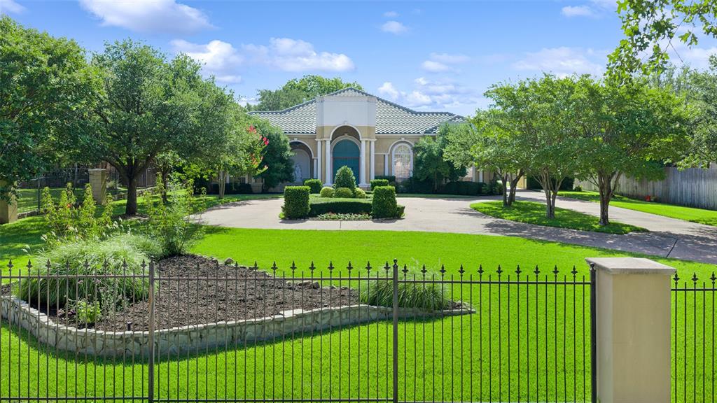 Behind a private electric gate on beautifully landscaped grounds, this exceptional Mediterranean-inspired estate offers timeless architecture and remarkable versatility on an expansive Grapevine homesite. Thoughtfully designed with 3 bedrooms, 2.1 baths, and multiple living and entertaining spaces, the residence seamlessly blends everyday comfort with refined luxury. A grand foyer leads to elegant living and dining rooms before opening to the kitchen, beautifully appointed with a large center island, breakfast bar seating, abundant cabinetry, and a sunlit breakfast area. Anchored by a fireplace with custom built-ins, the expansive living room features French doors opening to the covered patio for effortless indoor-outdoor living. A family room with generous storage, private office, utility room with built-in cabinetry and sink, and powder bath provide exceptional functionality. Privately situated in its own wing, the primary retreat offers a sitting area, dual walk-in closets, private patio access, and a spa-inspired ensuite with dual vanities, soaking tub, and walk-in shower. Two generously sized secondary bedrooms feature walk-in closets and private vanity areas connected by a Jack-and-Jill bath. Designed for year-round enjoyment, the outdoor living spaces are exceptional. A covered patio overlooks the heated pool and spa with tranquil water features, while the beautifully landscaped grounds showcase mature trees, a peaceful pond, winding pathways, and multiple areas for relaxing and entertaining. A porte-cochère leads to a single-car garage, complemented by an attached 2-car garage and a detached oversized 4-car garage complete with a half bath and storage, offering exceptional space for collectors, hobbyists, or workshop needs. Combining elegant Mediterranean design, exceptional craftsmanship, and resort-inspired outdoor living, this distinguished Grapevine residence offers a rare opportunity to enjoy privacy, sophistication, and unparalleled functionality.