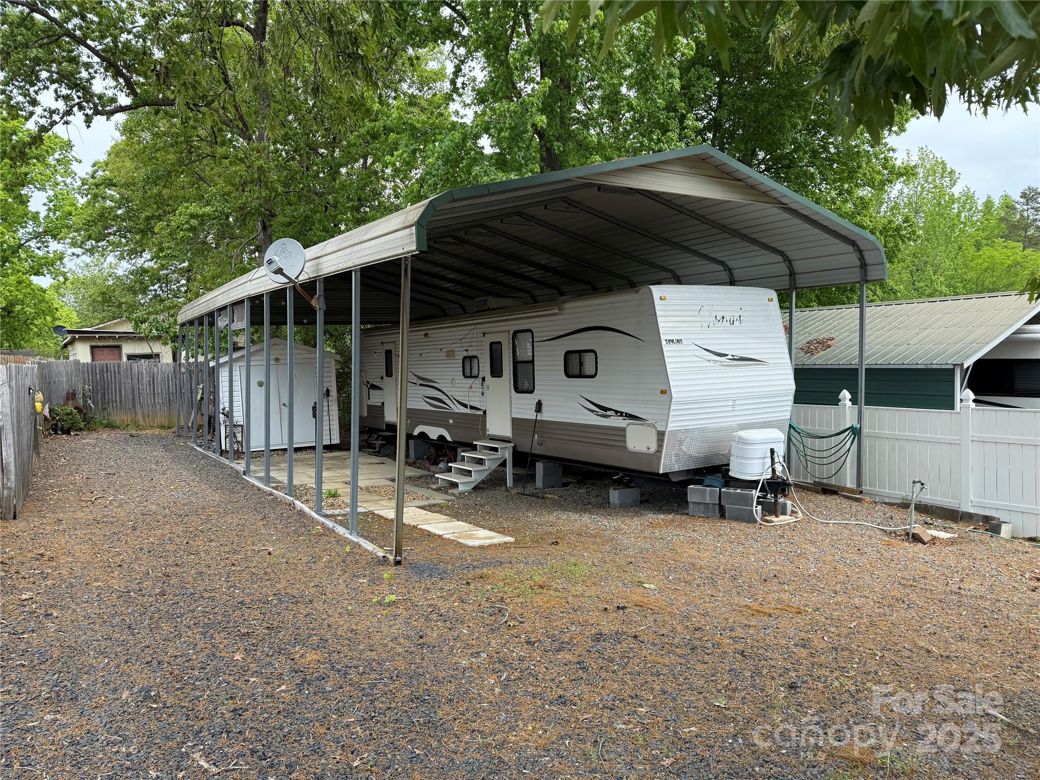 2009 Nomad 37' camper with 2 slides. Queen in main and 3 bunks in the bunk room. Metal carport over camper. Plenty of parking for all your toys. 10x8 Storage building with power. Tons of storage throughout. Come and see if this could be your "Happy Place" here in the park. The lot next door is for sale as well if you wanted 2 side by side. Bottle to camper, bill of sale will be provided. All clients must be with a realtor to gain access to the community.