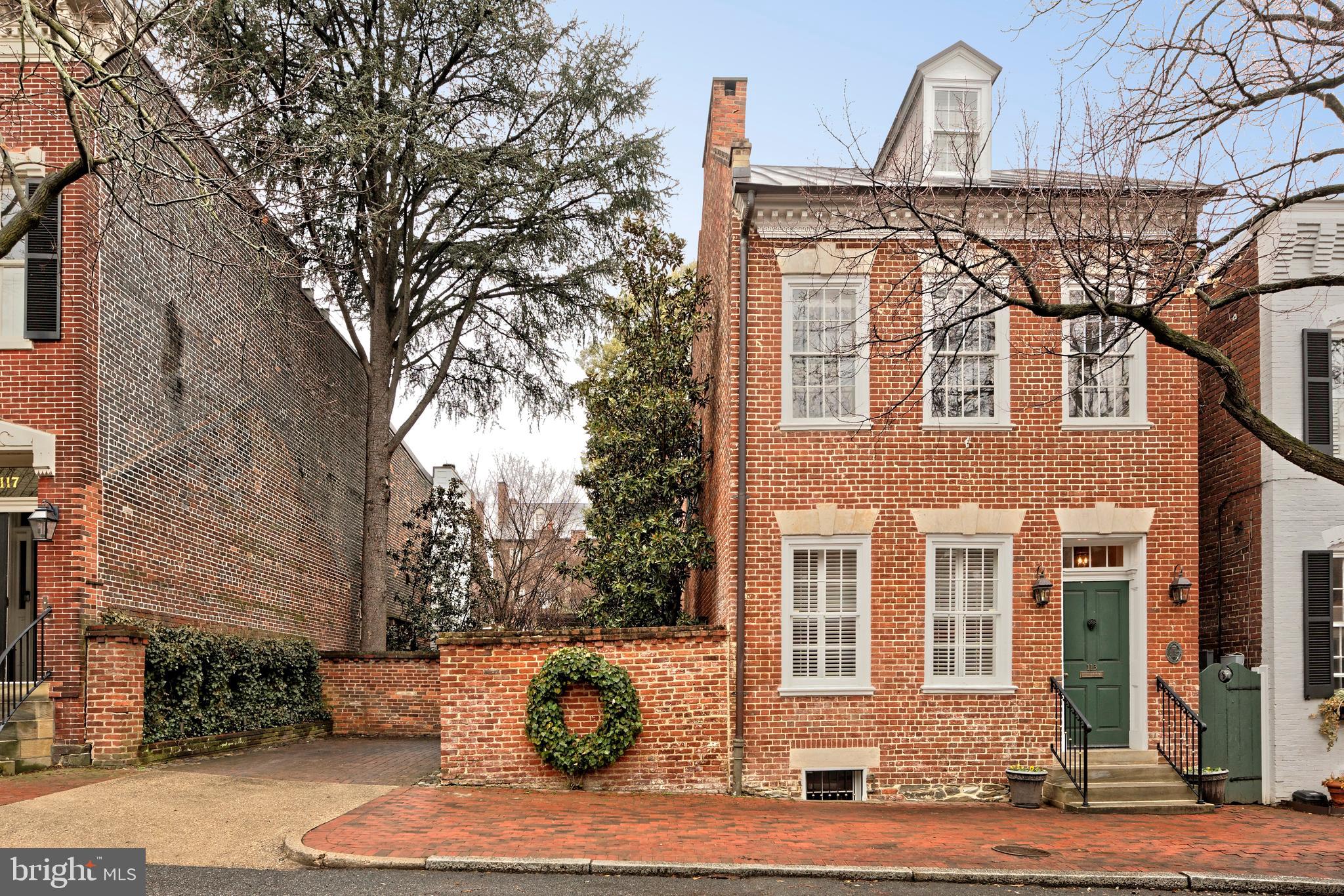 Nestled along one of Old Town's most cherished streets, 113-115 South Lee Street is a rare combination of a meticulously renovated 1790's residence plus an entire city lot 115 S Lee, which is a private garden offering unparalleled privacy.  This exquisite renovation showcases elegance with the finest craftsmanship, preserving original heart pine floors and maintaining all interior doors with authentic box locks. The home’s historical charm is further accentuated by intriguing, curved walls, a signature of the builder, William McVeigh.   Tall windows illuminate the double parlor living rooms with natural light and highlight the 10' ceilings.  Custom bookshelves and two fireplaces create a warm and inviting atmosphere.  A hyphen hall offers practical amenities such as a coat closet, wine racks, a beverage cooler, and additional storage.  The elegant dining room, with two windows plus French doors opening to the garden, provides an ideal setting for entertaining guests.  Exposed brick walls found in the half bath and in the kitchen framing the stove, add character and depth to the home.  The renovated kitchen is a chef's dream, featuring custom cabinetry, granite countertops, an eat-in area, garden access, and ample pantry storage complete this culinary haven.The second floor features a versatile study or dressing room, enhanced by a cozy gas fireplace framed with custom cabinetry. The primary suite is a serene retreat, boasting heart pine floors, a unique curved wall, and a custom walk-in closet with additional storage. Enjoy the convenience of a Miele stackable washer and dryer within a large closet, complemented by extra cabinetry. The luxurious primary bath includes a seamless glass shower with marble basketweave accent tile, heated floors, and a quartz-topped vanity.A sunlit hallway office creates an inspiring workspace, while the expansive family room, with its trio of windows, invites relaxation. Enjoy the warmth of a gas fireplace and showcase your treasures on the built-in shelving, featuring lighted glass display cabinets and open shelving. A well-appointed wet bar with a granite countertop, beverage cooler, and under-cabinet lighting makes entertaining a breeze. A full bath on this level offers heated marble floors, a clawfoot tub, and an apothecary sink.The third level offers three additional bedrooms and two full baths. The front guest suite impresses with heart pine floors, eave storage, and a full bath with a seamless glass shower and marble flooring.  Two rear bedrooms, including one with a Murphy bed, share a Jack-and-Jill bathroom with a sleek glass shower, offering both functionality and style.  The basement provides ample storage with waterproof walls and an epoxy concrete floor.The redesigned garden at 115 South Lee, crafted by landscape architect Joan Honeyman, is a masterpiece featuring two water elements, copper-clad trellises, terraced steps, upper and lower patios with a wood pergola, and custom lighting. An irrigation system ensures lush greenery throughout this private sanctuary. Additional highlights include audio speakers on the main level, family room, and garden, Kolbe windows, five new exterior doors, and copper roofs, gutters and downspouts, plus a new garden shed.  One off-street parking space completes this exceptional property.  Experience unparalleled privacy in this historic gem, where modern luxury meets timeless elegance.