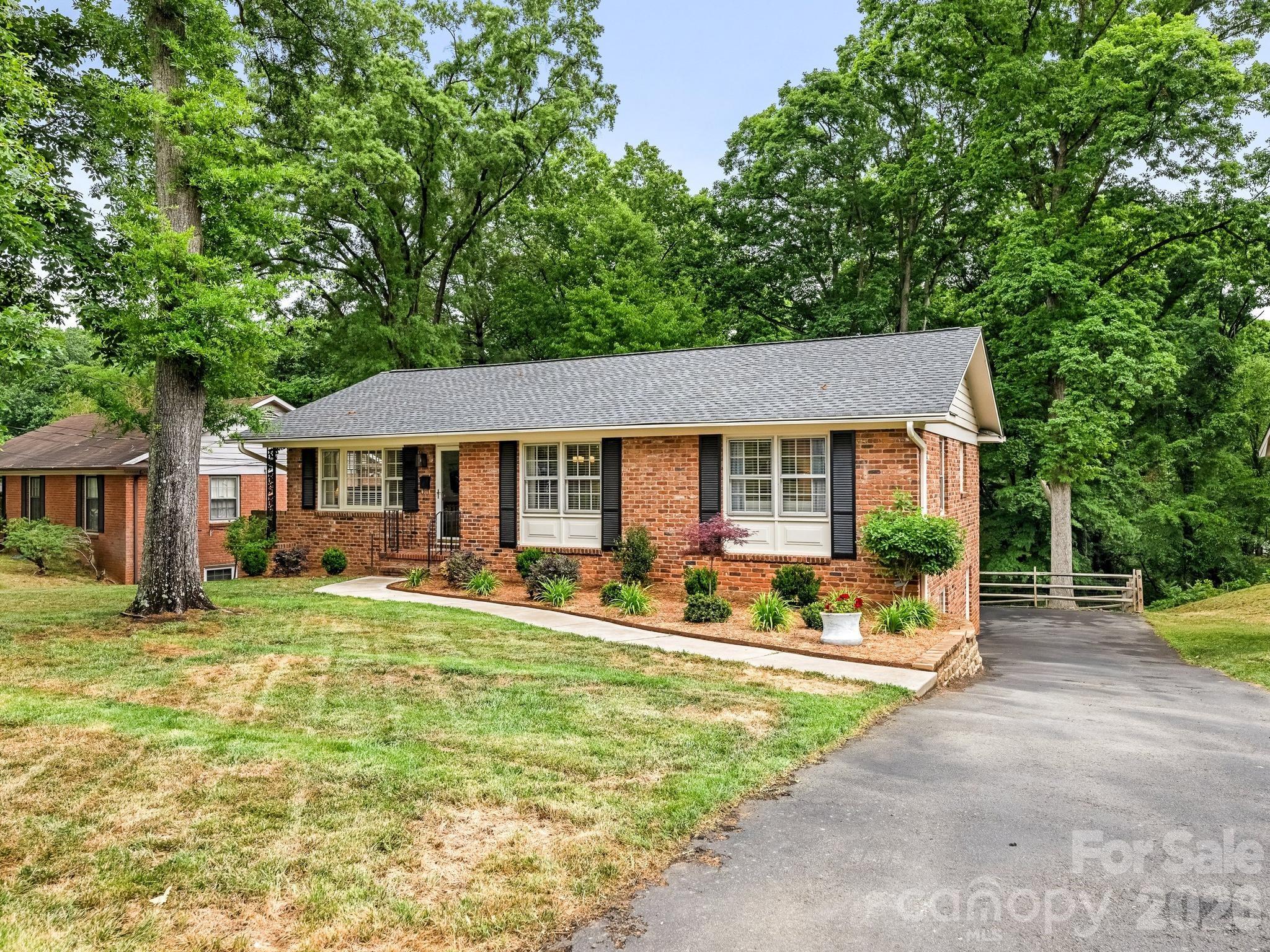 Welcome to 6115 Rosecrest, a classic brick ranch in the Starmount neighborhood, offering a blend of traditional character and modern updates. Inside, the main level features a bright living room with large windows and hardwood floors that carry throughout much of the home, creating a warm and inviting feel. The kitchen is beautifully designed with ample white cabinetry, newer stainless steel appliances, and quartz countertops and opens to a spacious dining area. All three bedrooms are located on the main level, each well-sized with good natural light. The finished walk-out basement provides valuable additional square footage, ideal for a secondary living area, home office, or recreation space. Set on a generous .34-acre lot, the backyard is fenced and extends to a peaceful natural area with a stream along the rear of the property. Conveniently located with quick access to SouthPark, SouthEnd, and the Archdale light rail station, this home combines an established neighborhood feel with close proximity to shopping, dining, and everyday essentials.
