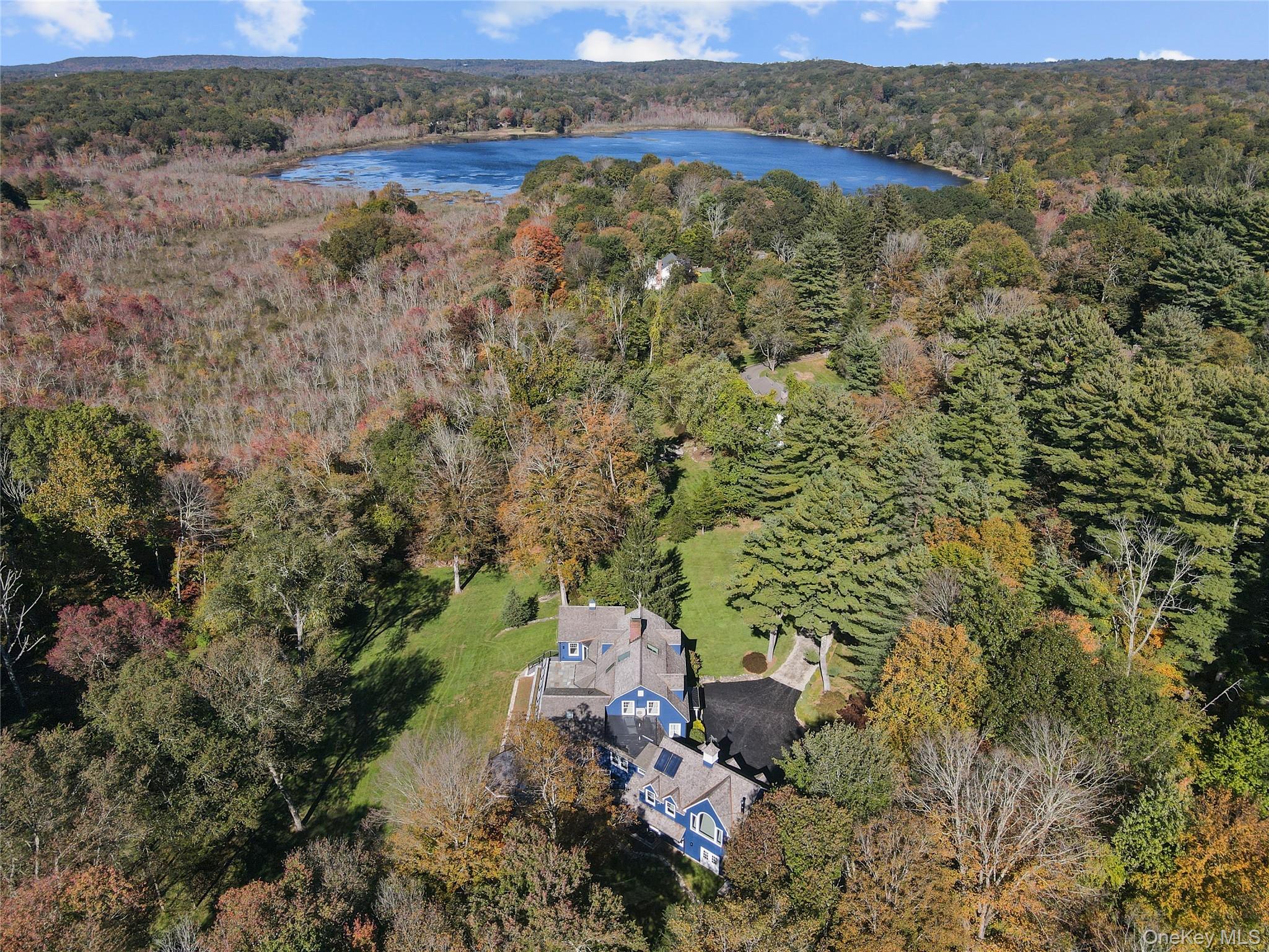 Ensuring privacy with in town convenience, this Pound Ridge home is beautifully sited on over 3 acres with incredible vistas, deeded lake rights, bordering 35 acres of protected Pound Ridge Conservation Land. This thoughtfully designed home combines timeless style with modern comforts.
 Breathtaking views frame the open, integrated living spaces, breakfast room with adjoining lounge area, and cozy sitting room with fireplace. At its heart lies a stunning cook's kitchen, wolf stove with double oven, Miele wall oven, two dishwashers and subzero. Direct access out to a brand new composite deck and grand bluestone terrace complimented by tiered beds for lush gardens.The classic living room with fireplace, custom millwork and refined built-ins, perfect for all to gather. The sprawling family room with soaring beamed ceiling, set a dramatic tone and showcase the natural light and panoramas. Luxurious primary bedroom/bath, offers a true retreat, complemented by two additional ensuite bedrooms and second floor laundry. Featuring a private wing seamlessly connected to the main house, ideal flexibility for guest quarters, office, in-law or multigenerational living with its own outside entrance. The sunlit third floor offers a bonus room for play/recreation/media/exercise. An additional family bedroom /au pair/nanny and hall bath complete this level. Further highlights include a three-car garage, wood shingle roof, freshly paved driveway, generator and the rare sense of space and tranquility that defines the best of Pound Ridge living.