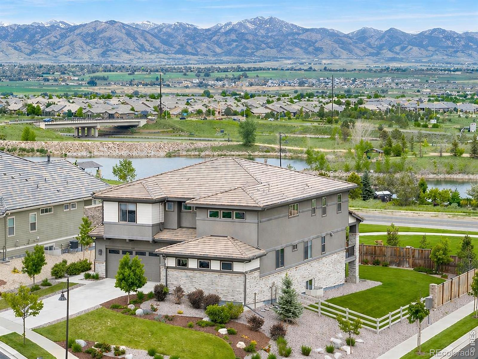 Where luxury meets nature-this former builder's model is ideally positioned on one of the largest premium corner lots, capturing sweeping views of Longs Peak, the Flatirons, and Sienna Reservoir. Every inch of this property showcases thoughtful craftsmanship, premium finishes, & intentional design that celebrates Colorado's natural splendor. Step into a soaring entryway that immediately impresses, leading into a sun-drenched great room with massive windows framing postcard-worthy vistas. The chef's kitchen is an entertainer's dream, anchored by a generous island & equipped with Sub-Zero & Wolf appliances, a beverage fridge, & a walk-in pantry. Wide-plank wood floors flow throughout the main level, where you'll also find a private office with built-ins & open views, & a main-level bedroom with an en-suite bath & walk-in closet. Retreat to the secluded primary suite upstairs-your personal sanctuary with a cozy gas fireplace, private terrace, & stunning mountain & water views. A spa-worthy five-piece bath features a soaking tub, oversized shower, & a walk-in closet. Three additional upstairs bedrooms & a spacious loft offer flexibility for family or guests. The lower level is designed for relaxation & entertainment, featuring a large rec room with a wet bar & fridge, a guest bedroom, & full bath. Modern conveniences include a wired security system, Tesla charger, solar-ready wiring, & epoxy-coated 3-car garage. Step outside to a peaceful covered deck & a backyard that opens to endless skies, walking trails, & the ever-changing natural beauty of Colorado. Watch hot air balloons in the fall, fireworks on holidays, & moonlight dance across the lake-all from the comfort of home. Residents enjoy access to the Anthem Rec Center, nearby charter schools, & effortless proximity to Boulder, Denver, & DIA. This is more than a home-it's a front-row seat to Colorado's most inspiring views.