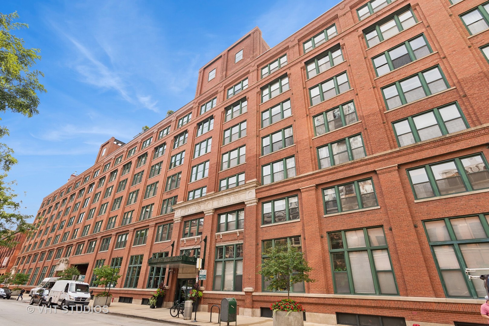 Experience true loft living in this stunning 2 bed, 2 bath home at the iconic Ontario Street Lofts. Featuring soaring ceilings, exposed brick and ductwork, and massive concrete columns, this residence delivers the classic industrial charm loft lovers crave. The open-concept living space is anchored by a cozy gas fireplace with black marble surround and gleaming hardwood floors throughout. The spacious kitchen offers stainless steel appliances, granite countertops, and ample room for cooking and entertaining. Retreat to the king-sized primary suite, complete with a large, professionally organized walk-in closet and an updated ensuite bath featuring sleek subway tile and a frameless glass shower. A generously sized second bedroom and a second full bath provide flexible living options, while the in-unit front-load washer and dryer offer added convenience. Enjoy your private, south-facing balcony and the peace of soundproof, dual-paned windows-no street noise here. A prime parking space is included. Ontario Street Lofts is a full-amenity building with 24-hour door staff, a well-equipped fitness center, private storage cage, bike room, and a beautifully landscaped rooftop deck. The building is financially sound and impeccably maintained-making it an exceptional place to call home.
