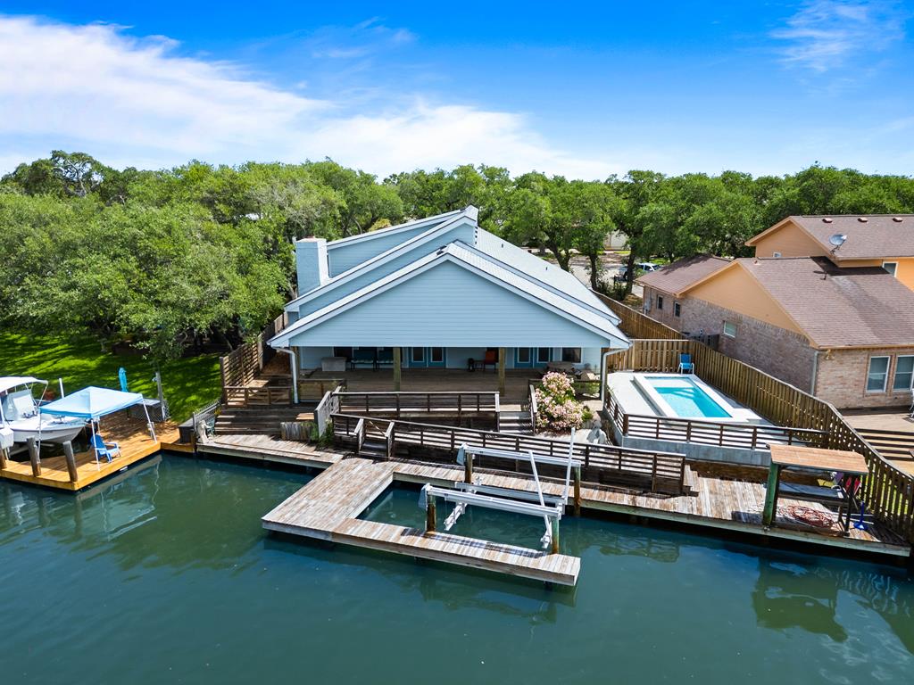 2321 Harbor Drive has been beautifully updated and thoughtfully remodeled to create the perfect blend of coastal elegance, comfort, and waterfront living. Positioned on an expansive canal-front lot, this exceptional property offers everything needed to embrace the Texas Coast lifestyle, from its private boat lift and fish cleaning station to the sparkling swimming pool and effortless access to the water. Designed for both entertaining and everyday living, the heart of the home is an impressive oversized rumpus room that seamlessly flows into the kitchen and inviting living area. Anchored by a cozy fireplace and framed by beautiful water views, this open-concept space creates the perfect setting for gathering with family and friends after a day on the water. Fresh interior paint and stylish updates throughout provide a light, welcoming atmosphere while allowing the home's timeless coastal character to shine. Step outside to discover an outdoor retreat designed for relaxation and recreation. The spacious covered deck overlooks the swimming pool and offers the ideal place to enjoy morning coffee, afternoon shade, or evening cocktails while watching the boats drift by. Just beyond, the private dock, boat lift, and fish cleaning station make launching your next fishing adventure both convenient and enjoyable. The thoughtfully designed floor plan offers a desirable ground-floor primary suite, providing privacy and easy accessibility. The spacious primary bedroom is complemented by an updated ensuite bath, creating a peaceful retreat at the end of the day. Upstairs, three additional bedrooms and two well-appointed bathrooms provide comfortable accommodations for family and guests alike. Whether you're searching for a full-time residence, weekend getaway, or vacation home, this beautifully refreshed Harbor Oaks property delivers the ideal combination of location, functionality, and waterfront lifestyle.
