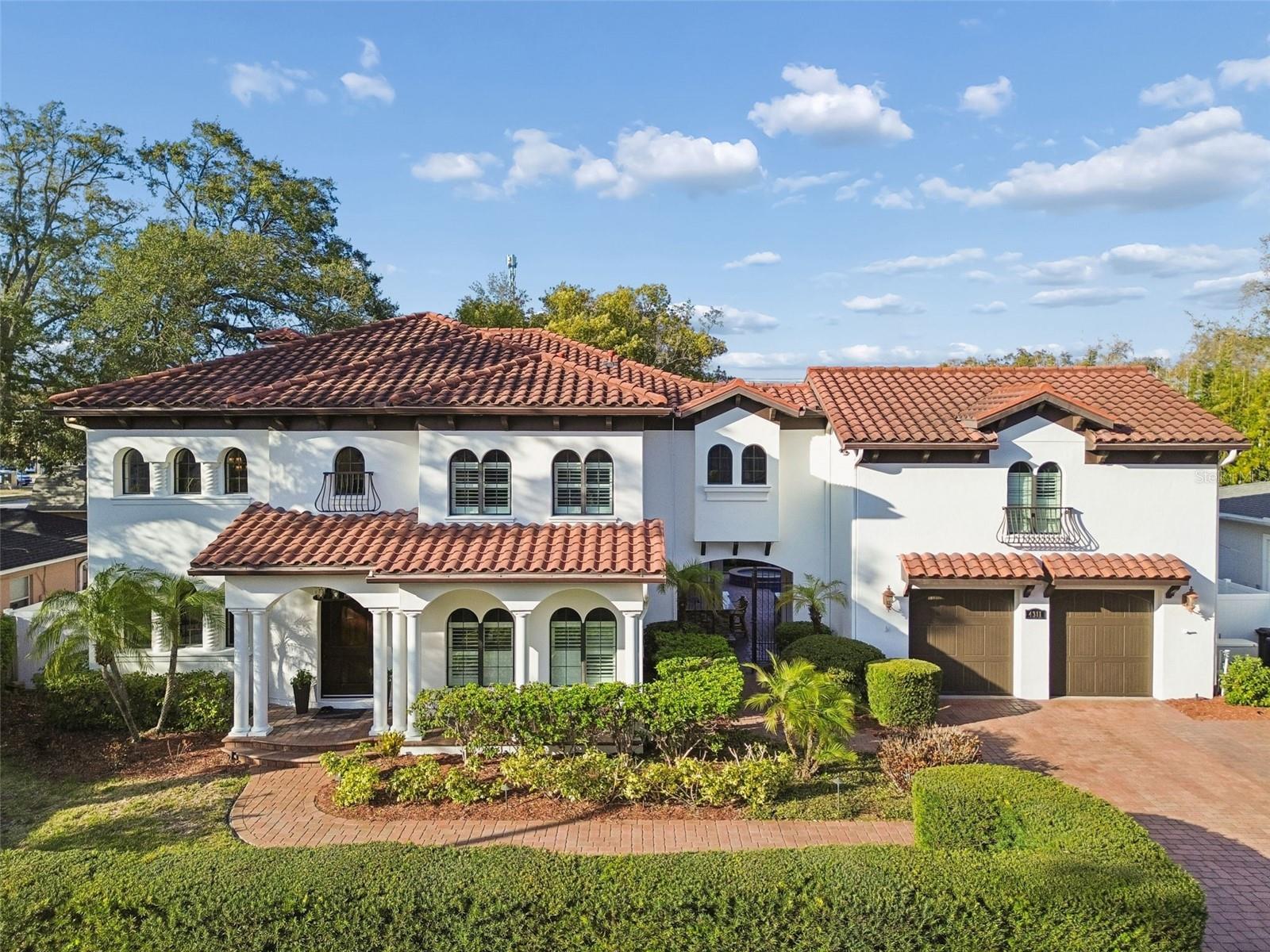 Nestled in the heart of South Tampa’s highly sought-after Palma Ceia area, this meticulously curated home is an architectural beauty. Situated on an expansive lot and outside the flood zone, this home offers peace of mind alongside its exceptional features.The formal entryway and spiral staircase greet you with elegance upon entering the home. The soaring 20’ cathedral ceilings, elegant chandeliers, and endless windows drench the space with light. The thoughtfully designed layout includes a convenient bedroom with an en suite bathroom on the first floor—perfect for guests or multi-generational living. The gourmet kitchen is a chef’s dream, featuring quartz countertops, high-end stainless steel appliances, and a walk-in pantry. A wet bar, dry bar, and wine cellar are perfect for hosting guests. From the kitchen, enjoy seamless flow into the dining and living spaces, where a cozy gas fireplace adds warmth and charm. A stunning wrought-iron spiral staircase leads upstairs, where the primary suite awaits with a spa-inspired en suite bathroom, dual sinks, a garden tub, and a walk-in closet. Crown molding, warm up lighting, and a balcony that overlooks the living area blend modern elegance and Mediterranean charm. An additional closet and cozy seating area make the primary suite a relaxing oasis. Four bedrooms remain, two of which feature en suite bathrooms for added privacy and convenience. The other two are situated in a separate wing, complete with a shared bathroom and a versatile flex space that could be used for storage or a home office. Additional home features include a brand new generator, two AC's (2021), plantation shutters throughout and whole home water softener system. Step outside, and you’ll find an outdoor retreat designed for both relaxation and entertaining. A brand-new pergola adds shade to the seating area, and turf ensures a lush, low-maintenance backyard. An outdoor kitchen, bar, putting green, covered porch, and ample seating are perfect for hosting parties or enjoying weekend fun.Located just minutes from top-rated schools, charming local boutiques, vibrant dining options, and the iconic Bayshore Boulevard, this home delivers the ultimate South Tampa living experience and offers a rare combination of luxury, functionality, and peace of mind. Schedule your private tour today!Televisions and window dressings do not convey.