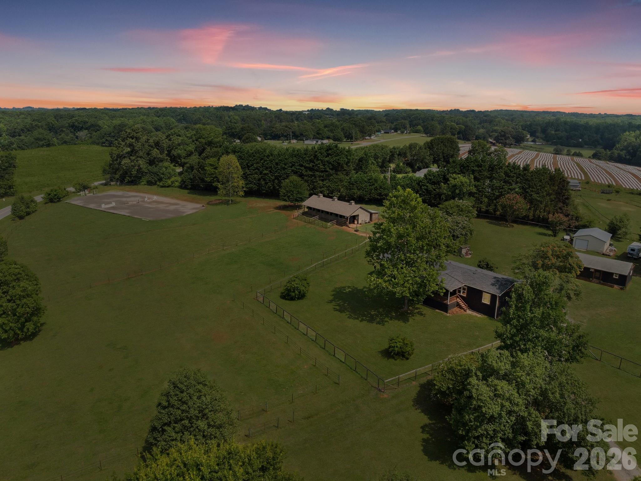 Searching for an equestrian property in Polk County that is updated, meticulously maintained and move-in ready for you and your horses AND also budget friendly? It’s finally here and it’s the only one of its kind in the area in this price range.  Perched on a scenic hill, this beautiful 12-acre property offers panoramic views of the surrounding countryside. The 4-bedroom, 3-bathroom home features a bright, open floor plan with designer-inspired farmhouse finishes. Quality details include quartz countertops, a stone fireplace, rustic beams and sliding barn doors. Extensive remodeling in the past 3 years includes major improvements -a New Roof, New siding, flooring, doors, exterior stain, interior paint and lighting.For your horses, there’s a 4-stall barn with an additional fifth pony stall, a dedicated tack room, and a wash rack. A riding arena with bluestone footing and acres of fenced pasture. You can ride the trail through your own woods down to the creek. Just 17 minutes from the Tryon International Equestrian Center, only 3 miles from the Green Creek Hunt Club fox hunting territory and a short drive to FETA trails which Polk County residents can obtain a permit to use, it's an equestrian's dream come true.An adaptable second building on the property, previously used as a country store, can easily be converted into secondary living quarters or a workshop. The property also features a storage building for farm equipment, dog fencing, a gated driveway, Spectrum fiber internet, and a concrete slab where an RV set-up or a second barn could be added. Don't wait to schedule your appointment to see this rare find.