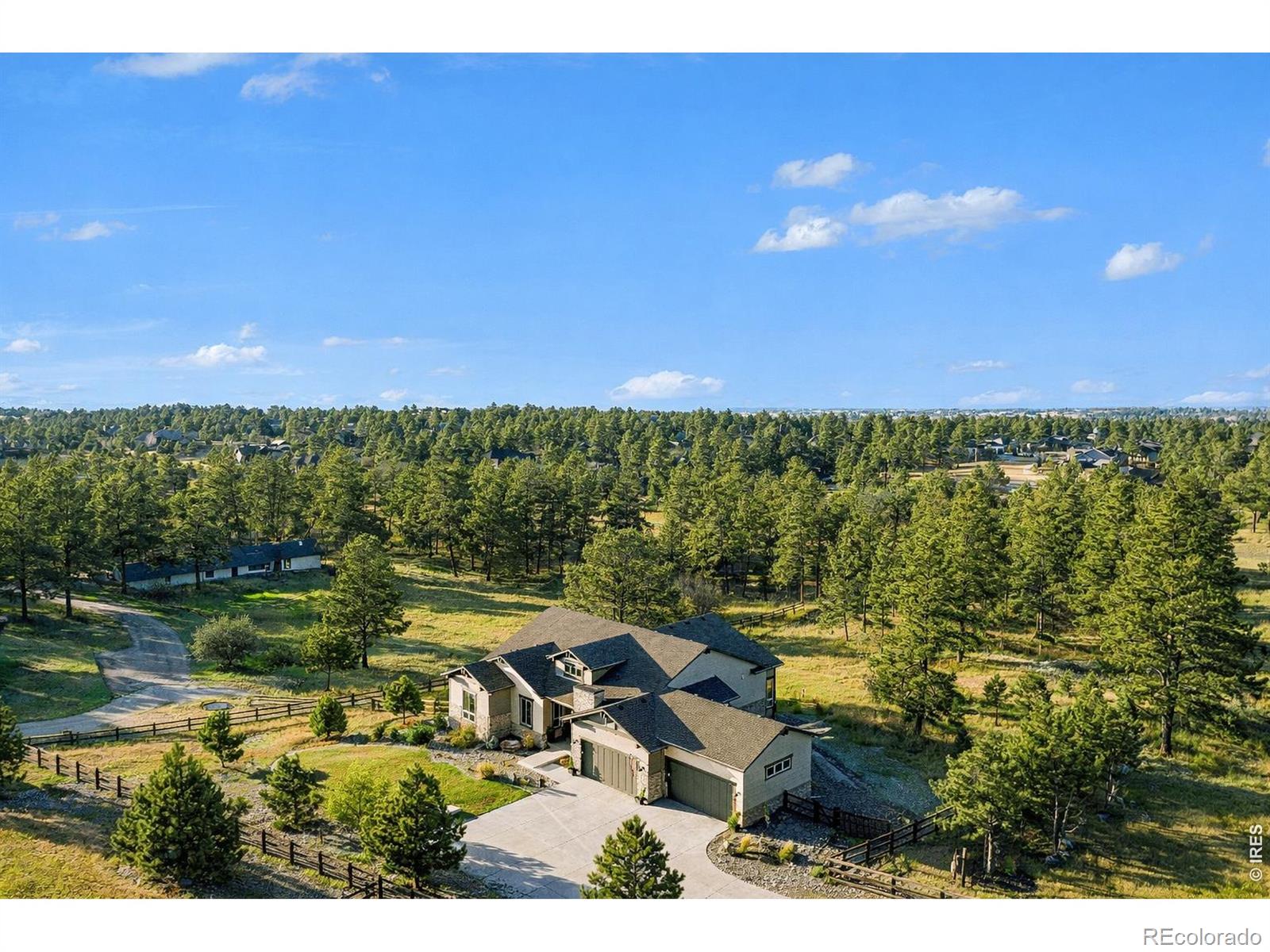 The largest lot offered in The Timbers in over four years-an exceptional 1.63-acre mountain contemporary retreat. Built in 2020, this custom home sits at the end of a 330-ft south-facing driveway within an exclusive 26-home community surrounded by mature 50-ft pine trees. A rare oversized heated 4-car garage with 220V service and epoxy floors provides space for vehicles and toys. Inside, soaring 12-ft vaulted ceilings, luxury engineered hardwood floors, and a multi-panel California sliding door create seamless indoor/outdoor living with mountain views, mature pines, and Colorado wildlife. The gourmet kitchen features a Cambria quartz waterfall island, KitchenAid appliances, 6-burner gas range, double ovens, beverage fridge, walk-in pantry, and abundant cabinetry. The main-level primary suite offers outdoor access and a spa-like 5-piece bath. Walkout basement includes rec space, bedroom, full bath, covered Dry-Below patio with hot tub, plus 1,193 unfinished sq ft for storage, gym, or expansion with wet bar stubbed in.