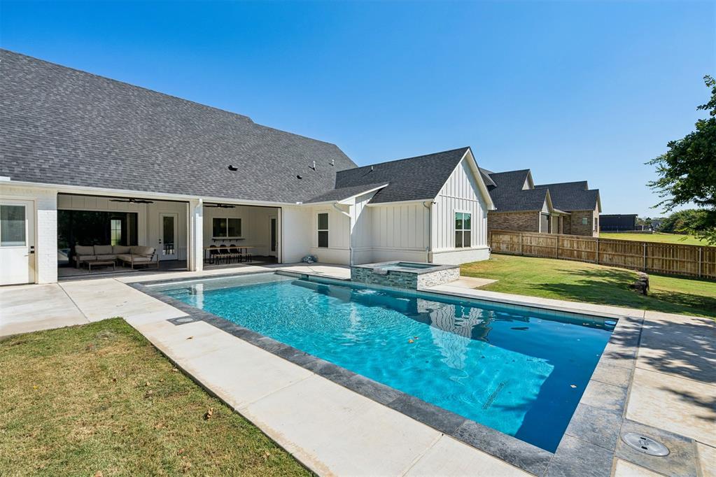 Hard-to-find single-level living with an incredible backyard designed for entertaining! This 4-bedroom, 4.5-bath home offers 3,962 sq ft all on one level, plus nearly 600 additional sq ft of temperature-controlled indoor/outdoor living space not included in the square footage. The thoughtfully designed split-bedroom layout provides exceptional privacy, with the primary suite occupying its own private area of the home. The primary bath features a freestanding tub, oversized shower, dual vanities and large custom closet with direct laundry-room access. Two additional bedrooms are tucked into their own area, each with a private ensuite bath, while the fourth bedroom is privately positioned near another full bath. Huge windows provide abundant natural light throughout the open floor plan featuring real hardwood floors, vaulted ceilings, dedicated study, dedicated dining area, spacious living room with fireplace and second living/bonus room with backyard and 1/2 bath access. The kitchen offers quartz countertops, large island, custom cabinetry, Miele appliances, 6 burner gas cooktop, convection oven, warming drawer and walk-in pantry with lots of storage. Outside is truly special with a heated, in-ground saltwater pool and spa overlooking the fully fenced .76-acre wooded lot. The  indoor/outdoor living area features heat and air, remote-controlled Phantom screens, tile flooring, gas hook up and fireplace and opens directly to the pool. A custom wood-burning outdoor fireplace added by the sellers and Pennsylvania bluestone walkway create another inviting gathering area. Additional features include motorized window shades, 3-car garage, storm shelter, spray-foam insulation, private well, aerobic septic, sprinkler system and built-in security system. An exceptional combination of privacy, entertaining space and single-level living!