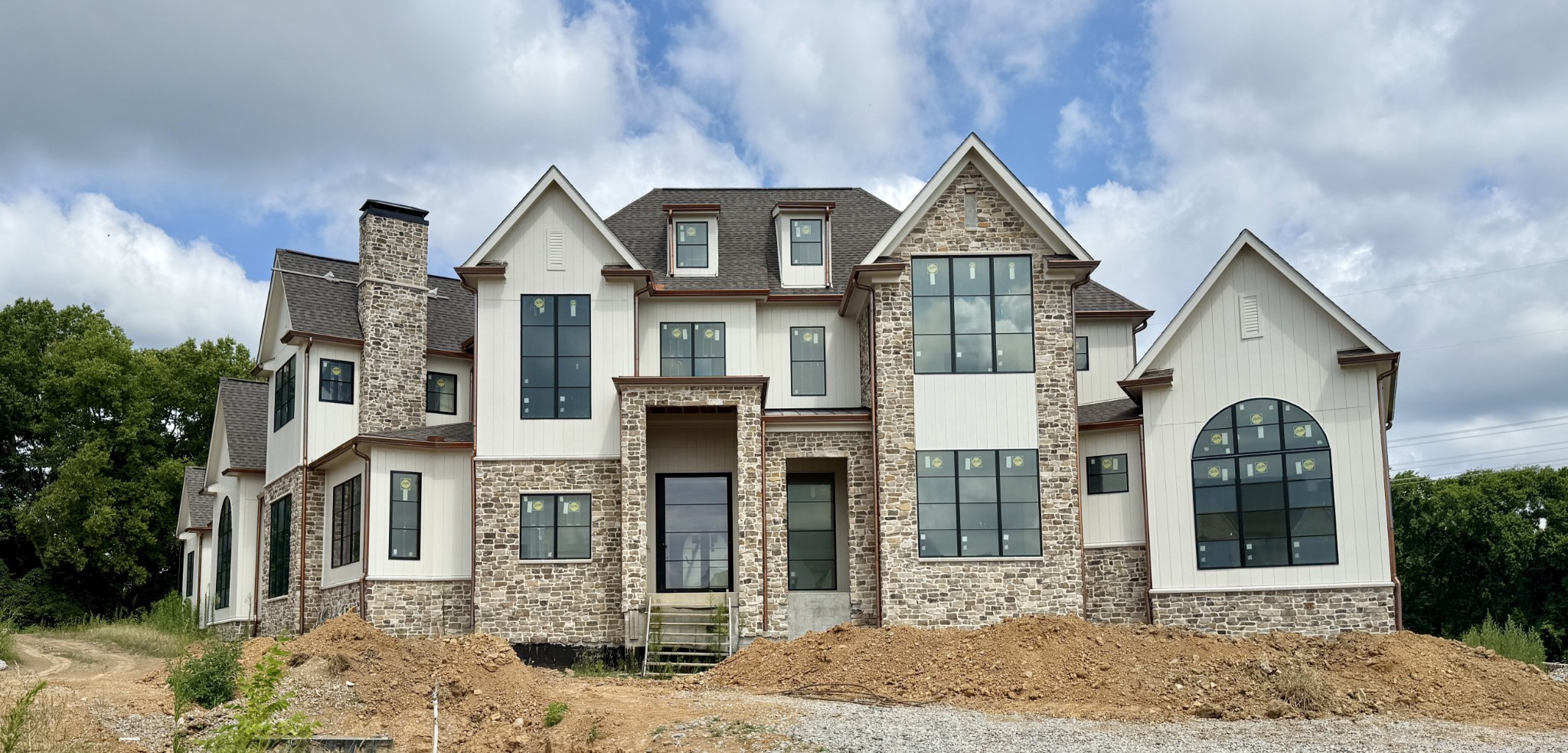 This custom luxury home by award-winning Arnold Homes is a masterpiece of elegance and functionality. A covered porch with an iron swing door welcomes you into an expanded foyer, which flows seamlessly into the open living and dining areas. Three sets of double doors provide breathtaking views of the rear covered porch, pool, and putting green. Designed for the ultimate culinary experience, the chef’s kitchen is complemented by a spacious Martha Stewart-inspired scullery. The opulent primary suite features a walk-around bar, a private office, and a dedicated massage room with a sauna. A breakfast terrace connects to a combined laundry and office space, offering added convenience. Perfect for entertaining, the covered porch is outfitted with a hibachi grill, pizza oven, and built-in grill with a vented hood. The main-level media and billiards room, which has access to a full bath, can also serve as a pool bath. Additionally, a connected poker room offers a private covered porch. Skylights flood the rear hallway with natural light, enhancing the ambiance of the space. The spa-like primary bath boasts a walk-through shower, separate his-and-hers vanities, private water closets, custom walk-in closets, and access to a stackable laundry. Upstairs, four additional bedrooms each feature en-suite baths, along with a separate walk-in laundry area for convenience. A dedicated podcast room near the bonus room includes built-in bunk beds and access to a large storage space. Car enthusiasts will appreciate the five-car garage with high ceilings, allowing for car lifts. Nestled on a private cul-de-sac street, this estate is surrounded by lush trees and features a luxurious pool, spa, and putting green—offering a resort-like experience at home.