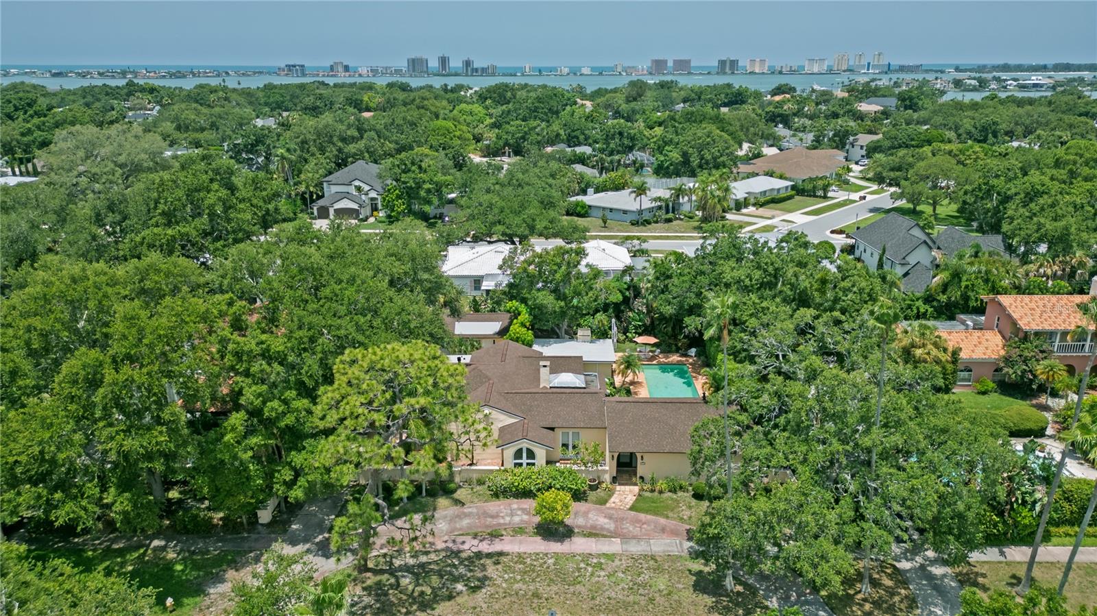 Nestled in the heart of Belleair, this enchanting 1925 Mediterranean estate is a rare architectural gem filled with timeless character, flexible living options, and endless potential. Set on a private tropical property with no HOA, multifamily zoning, and a 2023 roof, this distinctive residence offers exceptional versatility for multigenerational living, guest accommodations, or a unique estate-style retreat in one of Pinellas County’s most desirable coastal communities. Belleair is known for its beautiful residential setting, established charm, nearby parks and sports courts, and exceptional recreational opportunities. Just across the street, you will find the Belleair Country Club, Pelican Golf Club, and the recreation center, which hosts soccer games, pickleball matches, and summer concerts. The property is also just minutes from Gulf beaches, dining, shopping, and the relaxed Florida lifestyle. The main residence features over 3,331 square feet of living space and is highlighted by two inviting atriums that fill the home with natural light and create a seamless connection between the interior spaces and surrounding tropical landscape. At the center of the home, the unique sunroom overlooks the pool and lush gardens, creating a memorable focal point and a peaceful space to relax or entertain. An adjacent playroom adds even more flexibility for everyday living, recreation, hobbies, or additional gathering space. The spacious primary suite offers direct pool access, two walk-in closets, and generous proportions. Two additional bedrooms each feature their own en suite bathrooms, with one also enjoying direct access to the pool. The fifth bedroom could also be used as a private office with custom built-ins, providing an ideal workspace or creative area, while the layout throughout the home offers excellent storage, including a former wine cellar, and a variety of spaces that can be adapted to fit the next owner’s needs. Rich in original architectural details, the home showcases beautiful hardwood floors, classic Mediterranean terracotta tile floors, original stained-glass windows, and a warm sense of history throughout. The kitchen is located adjacent to the formal dining room and offers abundant cabinetry. Located beside the detached two-car garage, the guest house offers approximately 633 square feet of living space, complete with one bedroom, one bathroom, a full kitchen, and a 126-square-foot enclosed porch. This separate living space adds tremendous value and flexibility, making it ideal for extended family, guests, a private retreat, or additional multifamily use. Outside, the extra-long, deep pool is surrounded by mature tropical landscaping, creating a private and serene backyard setting. The pool would benefit from resurfacing, giving the next owner an opportunity to personalize the outdoor space and bring their own vision to the property. Restore this Mediterranean masterpiece to its original grandeur and create your own dream property in the heart of Belleair. Don’t miss this rare opportunity to own one of the area’s most distinctive homes.