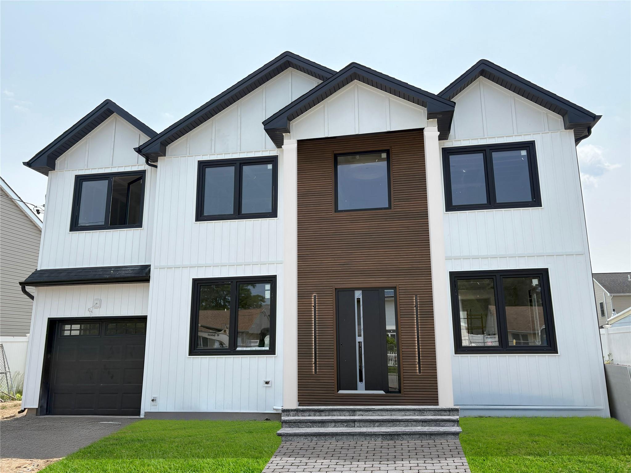 Welcome to this stunning modern NEW CONSTRUCTION home in heart of Plainview built by a Master Builder. This 5 Bedroom 5 Bathroom open concept home features a two story foyer entry with a modern chandelier that welcomes you to this sun flooded masterpiece. There is 9 foot ceiling on first floor and primary bedroom and 8 feet ceiling on rest of the house. White oak hardwood flooring throughout the house. Dining room with beautiful custom accent wall. Living room with tray ceiling. Family room with electric fireplace and accent wall. The state of art kitchen with high end stainless steel appliances, Quarts countertop, under cabinet lighting, Kitchen Island with seating, a wet bar with wine fridge and a pantry. Bedroom/Office located on first floor with ensuite full bathroom. HIDDEN STAIRS with modern glass handrails takes you to second floor. Large primary bedroom suite with 9 feet ceiling, custom built walking closet and a luxury spa like bathroom with free standing tub, double vanity and rain head shower. Junior suite with ensuite full bathroom. Two additional bedrooms. Full elegant main bathroom. laundry room on second floor. full unfinished basement with outside entrance for easy access to a good size fenced backyard with large paved area. 
Additional Features: Wiring for TV cable and internet in every room.spray foam insulation through out the house. Large paved area front and back of the house. interior photos are from previous houses this builder has built. This house will be completed by end of July/2025