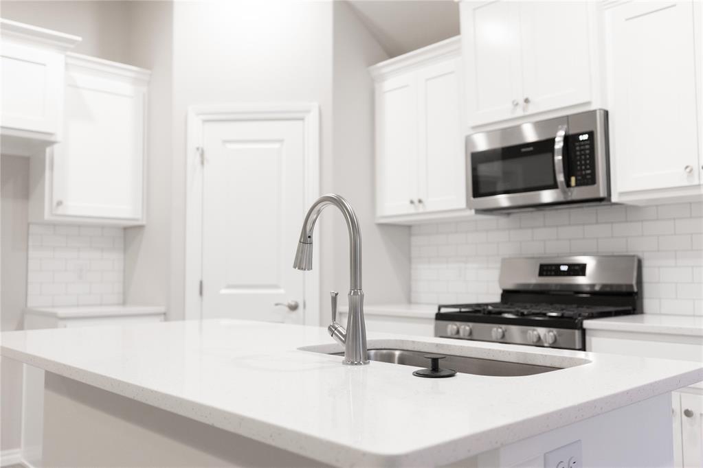 FENCING AND BLINDS INCLUDED! This Bogan floor plan includes 1,510 Sqft of total living space, which includes 1,400 Sqft of indoor living space and 110 Sqft of outdoor living space. There is also a 395 Sqft, two-car garage with a storm shelter installed. This home offers 3 bedrooms, 2 bathrooms, 2 covered patios, an office, and a utility room. The living room welcomes wood-look tile, large windows, a ceiling fan, and Cat6 wiring. The kitchen has 3 CM quartz countertops, stainless-steel appliances, wood-look tile, custom-built cabinets with decorative hardware, and stylish tile backsplash. The primary suite features noteworthy carpet flooring, a ceiling fan, Cat6 wiring, and perfect-sized windows. The upgraded primary bath offers a dual sink vanity with an elegant countertop selection, a tub/shower combo, an elongated water-saving toilet, and a walk-in closet! The outdoor living area is covered and has fully sodded yards with a water saving sprinkler system. Other amenities include a tankless water heater, a fresh air intake ventilation system, R-15 and R-38 insulation, an air filtration system, and so much more!