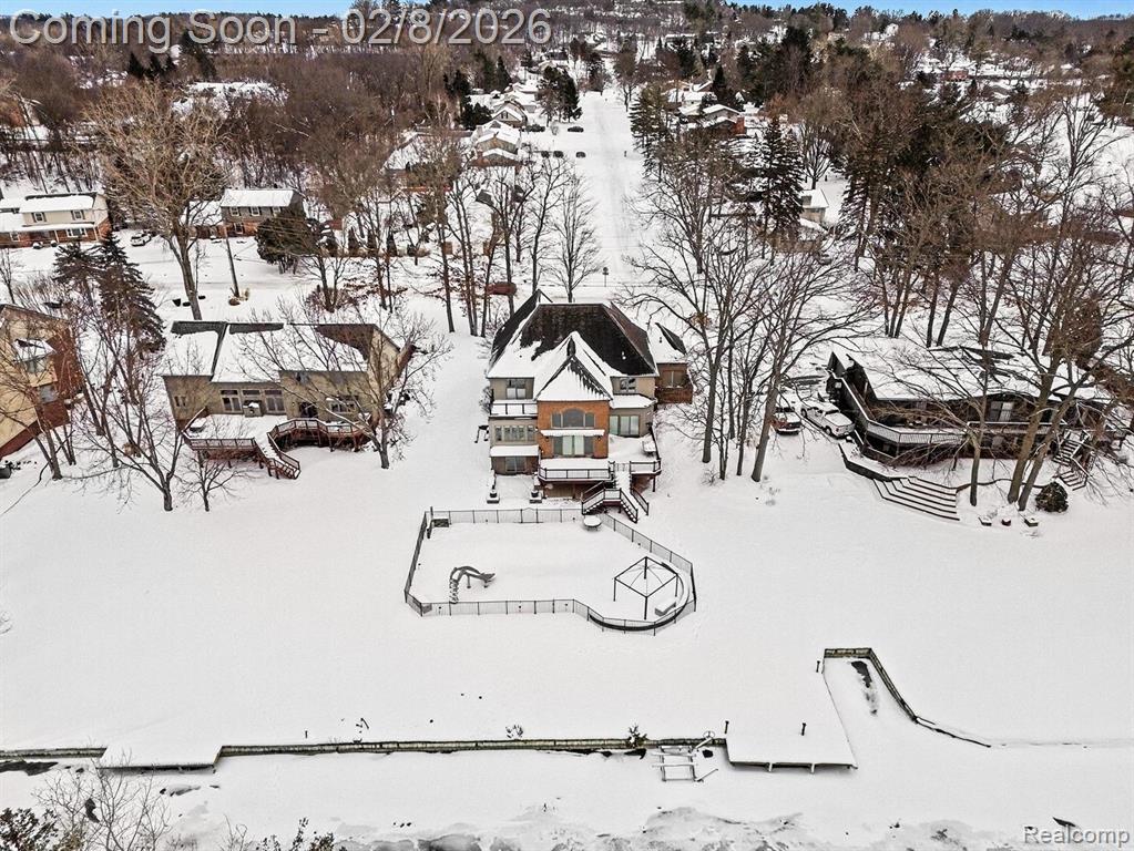 Perfectly positioned in the highly desirable Waterford Hill community, this custom, impeccably maintained lakefront home on private, all-sports Greens Lake delivers refined luxury living with exceptional indoor-outdoor amenities. Set on a beautifully landscaped 0.54-acre lot surrounded by mature trees, this residence offers rare privacy, panoramic water views, and a true resort-style lifestyle—complete with a saltwater pool. Inside, a bright, open-concept floor plan is enhanced by gleaming hardwood floors, custom Pella windows, and soaring two-story ceilings that flood the home with natural light. A cozy fireplace anchors the main living space while showcasing uninterrupted lake views. The chef-inspired kitchen features quality cabinetry, quartz countertops, a custom island, and a breakfast nook with sliding doors to expansive lakeside decking—ideal for entertaining. A main-floor library/home office provides a perfect remote-work solution, complemented by a convenient laundry room. Upstairs, the luxurious primary suite offers a private balcony overlooking the lake, generous closet space, and a spa-style ensuite with dual vanities, jetted tub, and separate shower. Two additional bedrooms—including one with a walk-in closet—a full bath, and an airy loft complete the upper level. The finished walkout lower level adds over 1,800 square feet of living space, featuring high ceilings, a fireplace, full bath, and abundant storage—ideal for guests, recreation, or extended living. Outdoors, discover a true entertainer’s paradise with a sparkling pool, BBQ area with wet bar, third fireplace, and breathtaking lake views. Additional highlights include a heated 3.5-car garage with epoxy floors, extensive parking, access to Van Norman and Lester Lakes, and adjacency to serene Bay Court Park for unmatched privacy and natural beauty. Clarkston Schools via school of choice. Lovely gardens featured on the 2018 Garden Walk. Live the lake life without compromise. Recent appraisal at $1.344M available for review. IDRBNG