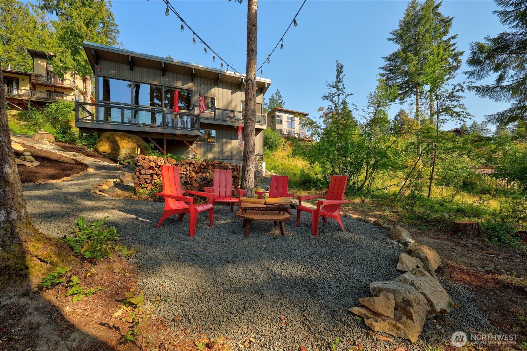 This one-of-a-kind, mid-century updated shed-style cabin is proudly offered by the second owners & sits above town on Alpine Drive in the desirable Skyline neighborhood. It masterfully blends timeless character with mid-century modern finishes, including exposed post & beam timber framing, expansive picture windows, & warm wood accents throughout. Set on a surveyed, treed lot, the home captures peaceful territorial views & a peek-a-boo glimpse of Mt. Rainier from inside, while the expansive multi-level decks, outdoor fire pit, & entertainment area deliver breathtaking, unobstructed mountain vistas perfect for spectacular summer sunsets while gazing at Mt. Rainier; an unforgettable setting for morning coffee, evening gatherings, or simply unwinding amid the trees. Every detail has been lovingly updated from top to bottom. The open-concept living spaces create a bright, inviting atmosphere perfect for relaxing or entertaining. Extensive drainage, natural rock retaining walls, & exterior improvements ensure lasting quality & peace of mind. Just minutes from downtown Packwood, White Pass Skiing, Mount Rainier NP, the Cowlitz River, & year-round recreation, this special mountain home is ideal as a full-time residence, getaway, or investment. The adjacent lot may also be available exclusively to the cabin buyer, offering a rare opportunity to expand privacy & outdoor living or to build.