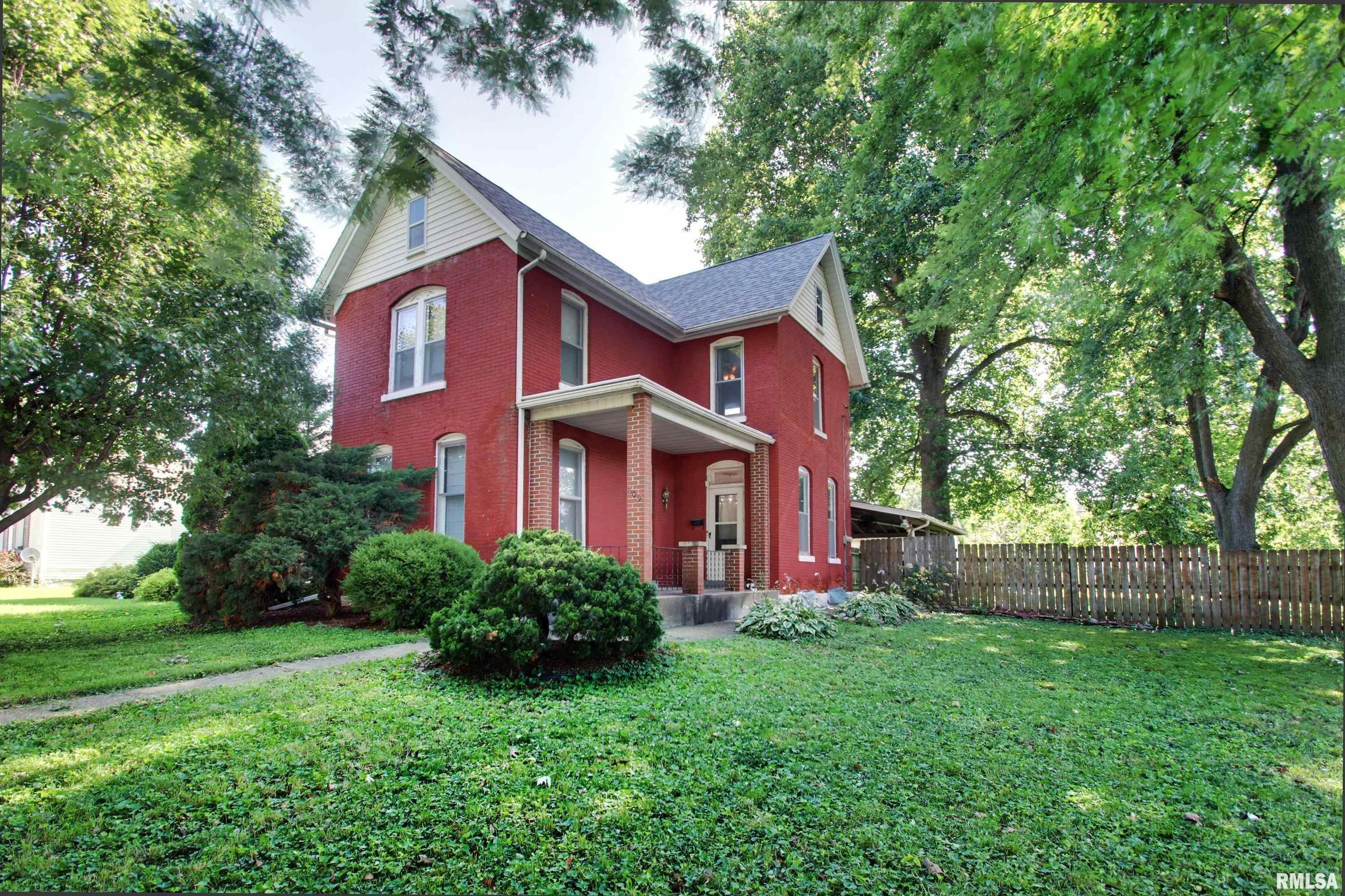 Welcome home to this charming 2-story brick home offering 4 bedrooms, 2 full bathrooms, and timeless character throughout. From the moment you step inside, you'll appreciate the beautiful original woodwork that adds warmth and craftsmanship to every room.  The spacious main level features a convenient laundry area and a private primary suite with a full bathroom, providing comfortable one-level living. Upstairs, you'll find three additional bedrooms and a second full bathroom, offering plenty of space for family, guests, or a home office.  Outside, enjoy the large, fully fenced backyard with a privacy fence—perfect for pets, children, or entertaining. The covered back patio is an ideal spot for grilling, relaxing, or enjoying your morning coffee. A large detached two-car garage with alley access includes a dedicated workshop area, making it perfect for hobbies, storage, or projects. You'll also appreciate the expansive unfinished attic, offering abundant storage space or future potential.  Additional updates include a new roof installed in 2021, providing added peace of mind for years to come.