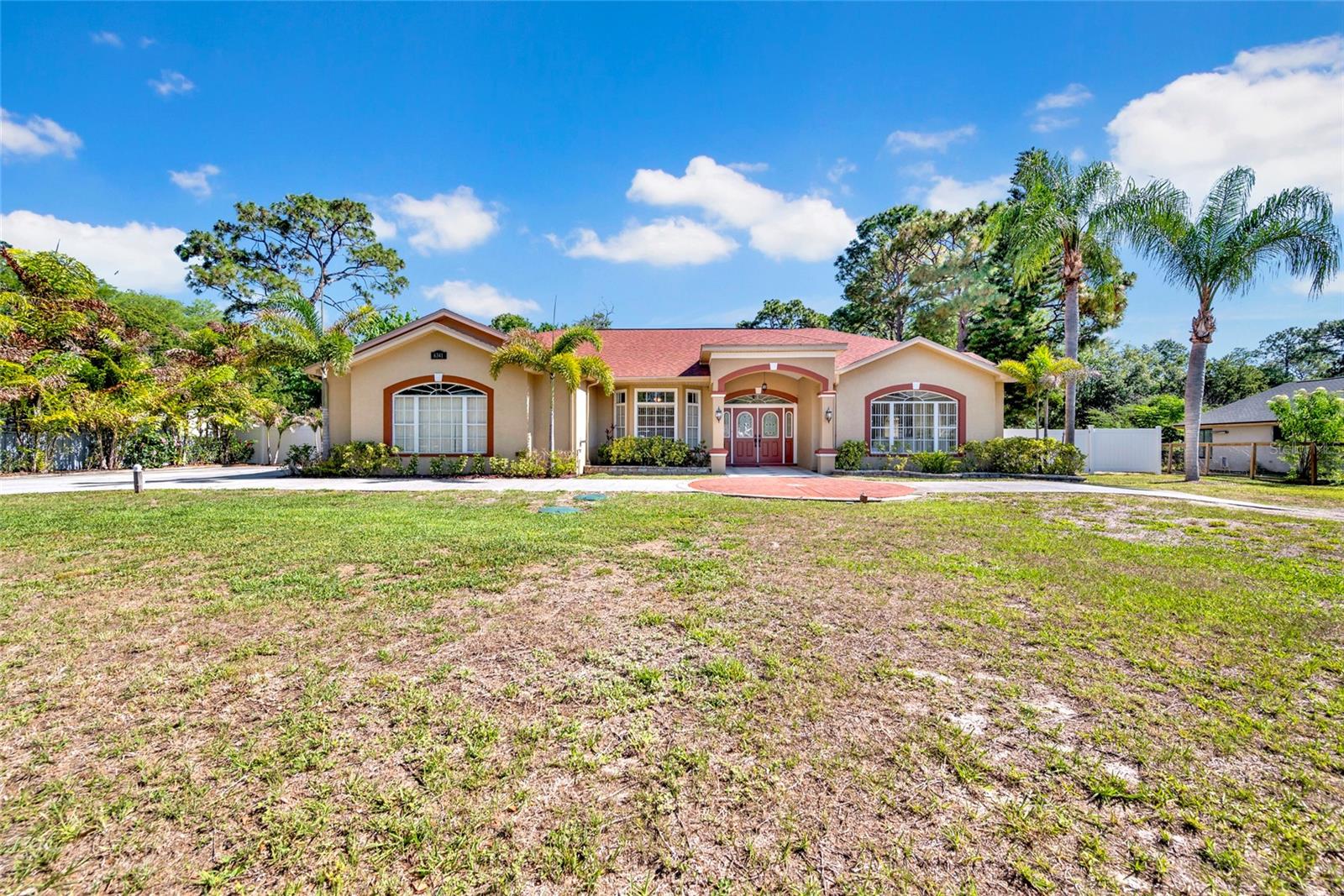 Fabulous jewel of a home in the sought after Oak Ridge community of custom built homes on 1+ acre lots nestled in the coveted 34655 zip code. Relaxed living within reach of all that the Trinity area has to offer! Beyond the double French doors awaits a thoughtfully designed layout spanning over 3,400 square feet, offering 4 bedrooms, 3.5 baths, and an oversized 2 car garage. Much of the heavy lifting has already been taken care of in this pet free home: Roof installed in 2018, 5 ton HVAC system is from 2016, water filtration system replaced in 2023, septic system last cleaned in 2025, water heater replaced in 2025, new deep well redrilled in 2023, LED lighting, ceiling fans, plumbing, plug added to electric panel for a generator should you choose to install one, and the list goes on! Outdoor enthusiasts  are in for a real treat with the largest pavilion style patio under a shingled roof! It truly is stunning, and adds over 650 SF of extended living space to your home!  It is the perfect spot for entertaining, family gatherings, or just chilling and relaxing. The open and spacious floorplan is just over 3400 SF, but feels larger with your wonderful outdoor living space overlooking your private grounds.  Imagine sipping your morning coffee, or cocktails, or meals, soaking in the gorgeous and peaceful views of your manicured backyard.  Or sitting around the fire pit enjoying nature. Ample room should you decide to add a pool, of any size!  And one of the baths would make an ideal pool bath. Seller has taken meticulous care of the home and now all of these improvements are yours to enjoy! As you enter your new home,  you feel the spaciousness of the large formal living and dining rooms, only to be surprised by the expansive kitchen, including dining and wet bar areas, which naturally adjoin the family room. Seller added (w/permits) almost 300 SF of additional square footage to the heart of this home! The chef's kitchen features plentiful cabinetry, a large island w/seating, granite countertops, SS appliances and a separate coffee bar. Your master suite is a private sanctuary and has sliders to your pavilion, a walk in closet and an ensuite bathroom with outdoor access to yet another private seating area. Second and third bedrooms are located by the second full bath. There's a third full bath and another guest half bath by the entrance. The fourth bedroom is currently used as an office, should you have a need for one. There is laminate or tile flooring throughout the home (no carpet).  The inside laundry room offers lots of storage, and also has exterior access.  Oak Ridge is Equestrian Zoned and allows up to two hooved animals per acre. Ample parking is available on the large driveway for your cars, boats, RV's, etc. Property is in "X" flood zone and lenders should not require flood insurance. There are no HOA or CDD fees, and this property can be used as a personal residence or an immediate investment property with no restrictions. Great location in close proximity to excellent schools, shopping, restaurants, medical facilities, parks and beaches. Enjoy rural tranquility with suburban convenience. Proximity to two international airports, Tampa, Clearwater and St. Pete, as well as Lake Tarpon and the famous Tarpon Springs Sponge Docks. Discover the peace of mind and prestige of life in Oak Ridge. Schedule your private showing today. Or check out the 3D Tour or video.  All room measurements are approximate and should be confirmed by buyer.