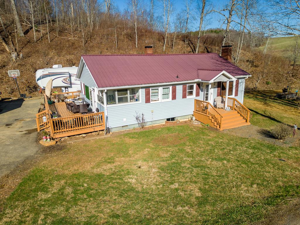 Check out this Blue Ridge Mountain Mini Farm! Great location within minutes of the scenic Blue Ridge Parkway and I-77. This lovingly maintained 2 bedroom, 1 bath home features hardwood flooring in the living room and under the carpet in both bedrooms.  Enjoy one level living with oil heat, gas logs, central a/c and basement with lots of built in shelving. Perfect for your crafts, hobbies or storage!  Has over 530 feet of decking for relaxing or entertaining.  Set on 1.37 acres with paved driveway, 50 amp RV hookup and a creek running along the full length of the property. Second creek runs along the lower side of the acreage. Perfect for a mini farm with chicken coop and pen already set up. Nice site for camper or small cabin at the top of property. Easy commute to Hillsville, Galax and NC! Don't miss this charming country home in a convenient location! Information deemed reliable but not guaranteed. Buyer to perform their own due diligence.