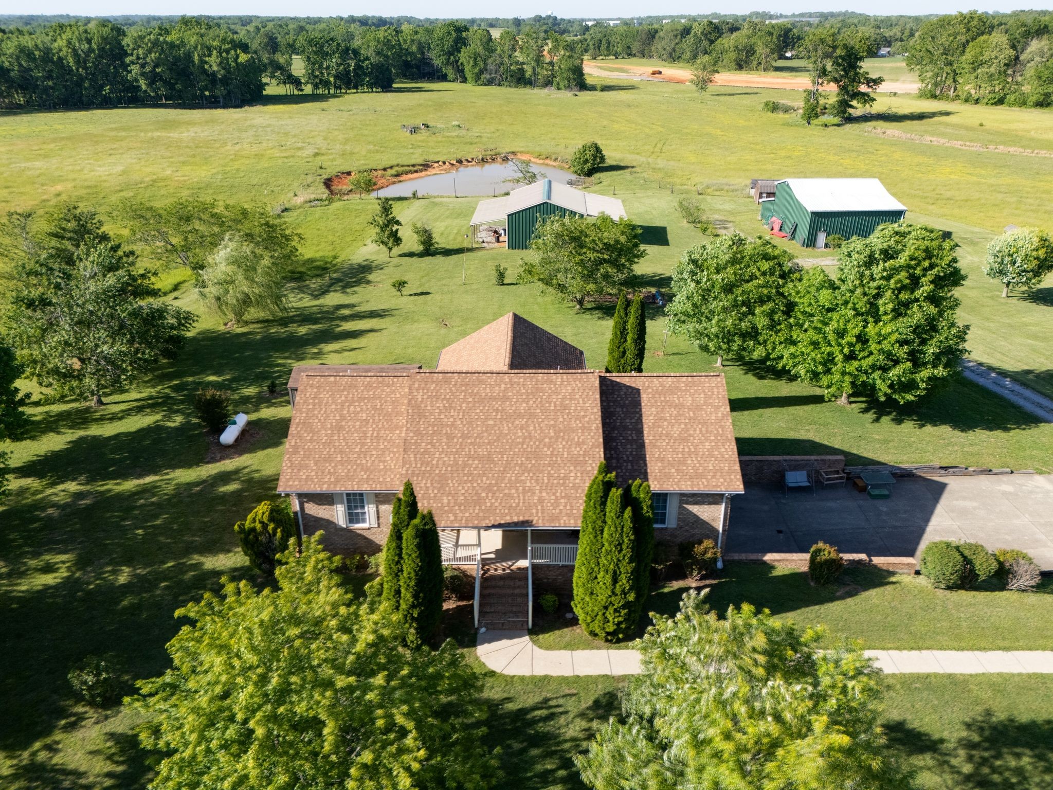 Tucked away just outside the city limits, this beautiful 27 acre property offers the perfect blend of privacy, space, and peaceful country living. Surrounded by scenic views and mature trees, the property features TWO ponds, a large barn, and storage shed. Ideal for hobbies, equipment, animals, or simply enjoying the extra room to spread out. Inside, the home offers 3 bedrooms, 3 full bathrooms, and a finished basement providing flexible living space perfect for a bonus room, home office, guest quarters, or recreation area. The huge sunroom is filled with natural light and overlooks the beautiful acreage, creating the perfect place to unwind year-round. A spacious back deck and welcoming front porch make it easy to enjoy the peaceful surroundings and outdoor lifestyle this property offers.