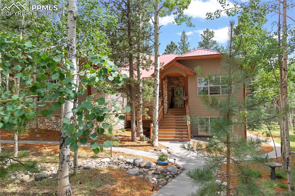 This 4,462 sf residence, on 1/2 acre wooded acres, offers a peaceful escape while being conveniently located to shopping, dining, and recreation. Enjoy visits from wildlife, including deer, fox, raccoons, and a variety of birds.
This home boasts 2 living areas, media center, 6 bedrooms, and 4 bathrooms, with a 3-car garage, energy efficient vinyl windows and low-cost hot water radiant heat. A combination of Saltillo tile, cozy carpet, and durable ceramic floors adds to the character. 
The main level Living Area has large windows and a cozy fireplace. The Informal Dining has easy access to the upper deck.
The Kitchen boasts granite counters, a large island, a gas cooktop, and stainless steel double oven, microwave, refrigerator, and dishwasher. A large walk-in pantry is nearby. For entertaining, the Formal Dining has carpet flooring, a convenient counter with a sink. The Guest Bath is nearby.
The Master Suite has carpet flooring, fireplace, dual vanity, jetted tub, stand-alone shower, and a large walk-in closet. A Laundry Room is located nearby. There are also 2 additional bedrooms with carpet, large windows, and by-pass closets. The Main Bath is nearby.
The lower Family Room has large windows and a walk-out. The Media Room is equipped with seating for 6 and high-quality B&W, Sony, and Macintosh audio/visual equipment included. The Lower Level Bath includes a dual vanity, ceramic flooring, and a tub-shower combo. There are 3 additional bedrooms on this level, all with carpet flooring, large windows, and closets. Two could easily double as offices. An additional Lower Level Laundry area is nearby.
Beyond the property, you can explore the vast wilderness of the Pike National Forest, enjoy hiking or picnicking at Manitou Lake, or the unique rock formations of Red Rocks. The North Slope Rec Area provides breathtaking views, extensive trails, and reservoirs. Embrace the endless opportunities for hiking, mountain biking, snowshoeing, and skiing right at your doorstep