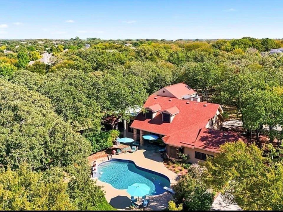 Set on over an acre in the heart of Keller, with no HOA, this one of a kind property offers the space, flexibility, and lifestyle you have been searching for. Surrounded by mature trees and tucked behind a gated entry, the setting delivers a rare sense of privacy while still being minutes from everything. Inside, the home features 6 bedrooms and 5 full baths, including two private primary suites which is ideal for multi-generational living or guests. A thoughtfully designed split layout with dual staircases creates both separation and connection, offering versatility for a variety of lifestyles, including work from home needs. The expansive living areas are filled with natural light and designed for both everyday living and entertaining. Your guests will be impressed with the curb appeal and impressive entrance into your oversized living room complete with a gorgeous stone fireplace.  Adjacent is your chefs dream kitchen which has an abundance of cabinets, large pantry, and KitchenAid appliances.  Step outside to your own backyard retreat, complete with a heated diving pool and a gazebo with a cozy fireplace, perfect for relaxing evenings or hosting gatherings year round. With a 4 car garage and over an acre of private, usable land, there’s plenty of room for additional parking, a workshop, or future customization, all without HOA restrictions. Opportunities like this are rare; acreage, privacy, and a prime Keller location near Southlake, Alliance Town Center, DFW Airport, shopping, and dining. Don't miss out on this opportunity to make this amazing estate yours!