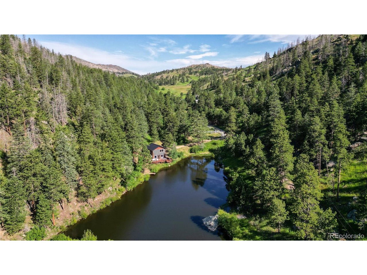 Escape to your own private Colorado mountain retreat where peace, privacy, and outdoor adventure come together. Whether you're looking for a full-time residence, second home, hunting property, or weekend mountain escape, this gated property offers a rare opportunity to own a truly unique piece of Colorado. Surrounded by an untouched natural landscape, the property features a private pond, abundant wildlife, and breathtaking views in every direction. Spend your days fishing, paddleboarding, hiking, camping, hunting, or simply exploring your own private acreage. As the sun sets, enjoy incredible stargazing and the tranquility that only a secluded mountain setting can provide. The beautifully remodeled home is designed to maximize natural light and capture the surrounding scenery, with expansive windows and outdoor living spaces that bring nature right to your doorstep. The upper-level primary suite offers a private retreat with its own entrance, deck, and panoramic views overlooking the pond and surrounding landscape. The land provides flexibility and opportunity, with ample room to build a custom shop, additional outbuildings, or create the mountain lifestyle you've always envisioned. Additional features include Starlink high-speed internet, separate heating and cooling systems on each level, all-electric utilities, and an established well and septic system. Zoned O (Open) with NO HOA and NO covenants, allowing you the freedom to enjoy and utilize the property to its fullest potential. The permitted dam and associated water rights will transfer with the property, making this an exceptional opportunity to own a private recreational retreat with fishing, hunting, water rights, and year-round enjoyment.