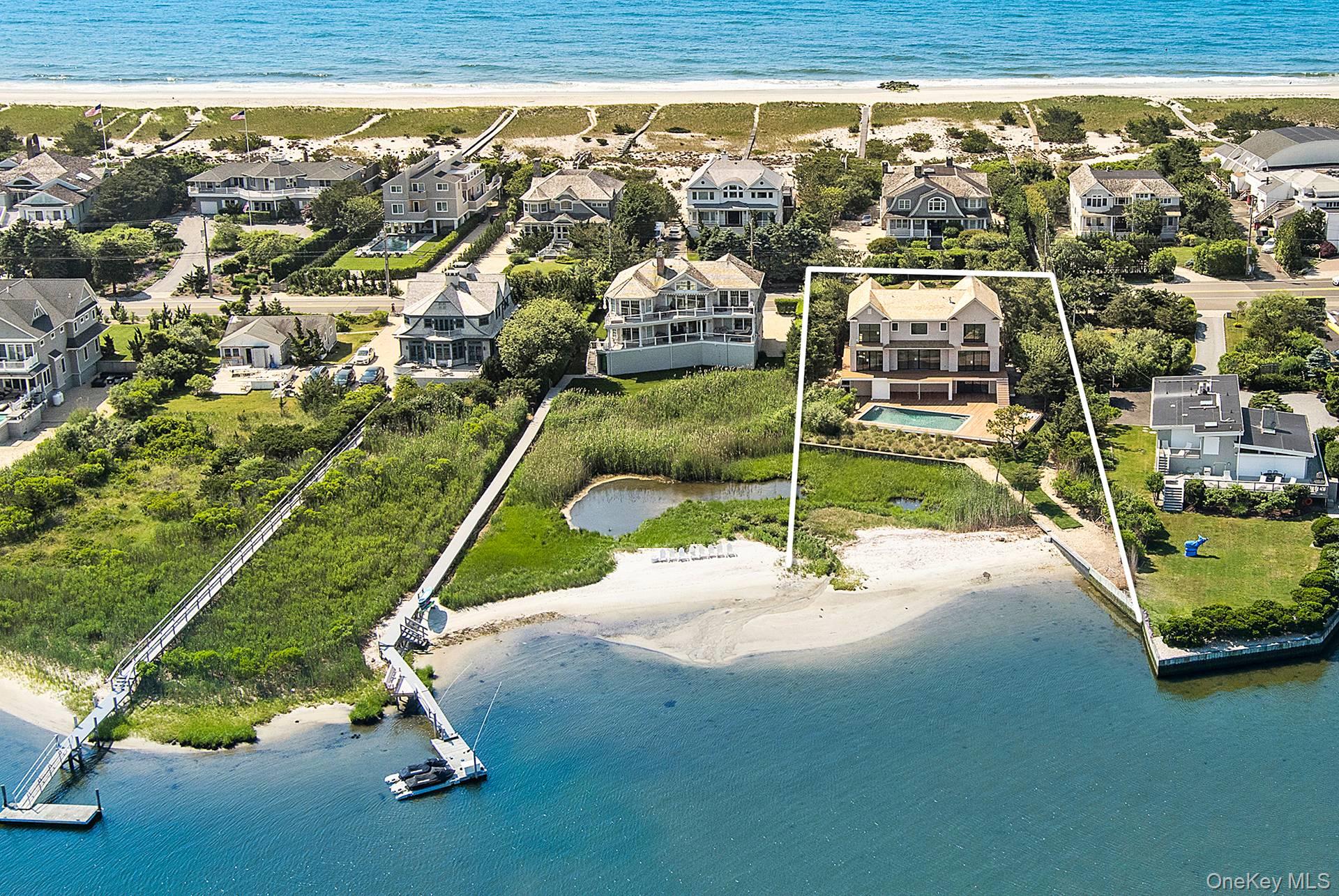 Discover luxury waterfront living at 218 Dune Road, Westhampton Beach. This stunning bayfront coastal oasis offers unparalleled elegance and comfort throughout 4,000 sf of living space. The traditional style architecture spans across 2 stories offering 5 bedrooms, including both a first-floor and second-floor primary suite, 5 full baths and 1 half-bath. The open and bright interior features a gourmet eat-In kitchen with top-of-the-line appliances, living room with cozy fireplace, family room, and den/office. Each room showcases the spectacular vistas with walls of windows and sliding glass doors leading to decks and balconies. Outdoors, enjoy breathtaking bay views, direct bay access, the in-ground, heated pool, and an expansive entertainment-ready deck surrounded by water views. Ample driveway parking plus 3 garage spaces and plenty of storage. Come to 218 Dune Road, located between the bridges, where every day feels like a vacation.