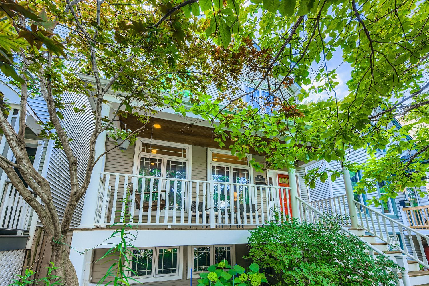 Welcome to this stunning extra-wide 4-bedroom, 3.1-bathroom home located on a quiet, tree-lined street in the heart of Lincoln Square. Thoughtfully designed and meticulously maintained, this home blends modern updates with classic charm. Step up to the inviting front porch, perfect for morning coffee or evening conversations, and enter into a spacious main level featuring a large living room with a wood-burning fireplace, and gleaming hardwood floors, The recently renovated kitchen is a chef's dream, boasting sleek cabinetry, quartz countertops, high-end stainless steel appliances, and a generous island with seating. Patio doors open to a large deck and a lush, secluded backyard oasis - perfect for summer gatherings or quiet relaxation. Upstairs, the luxurious primary suite includes a recently updated spa-inspired ensuite bathroom with a double vanity, walk-in shower, stand-alone tub, and high-end finishes. Enjoy your morning coffee or unwind with a glass of wine on your private balcony overlooking the serene backyard. Two large secondary bedrooms, hall bath, and laundry room complete this floor. The high-ceiling basement offers fantastic bonus space for a family room, 4th bedroom or home office, an updated full bathroom, plus ample storage.