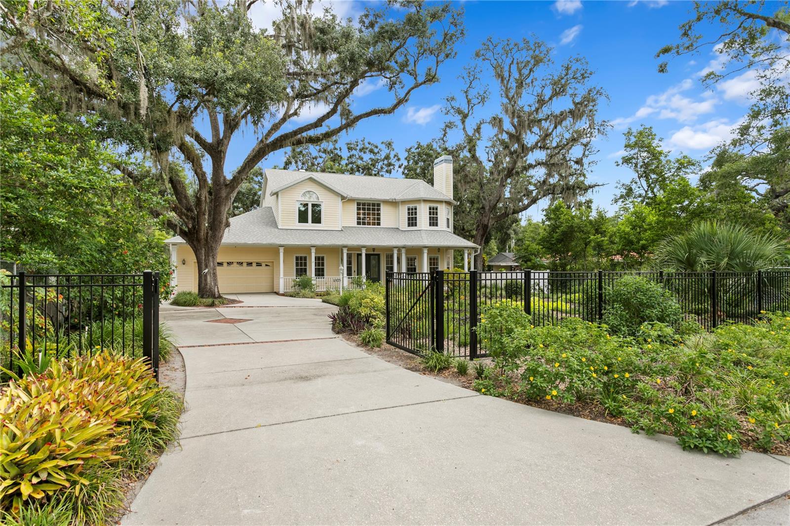 One or more photo(s) has been virtually staged. Welcome to this truly special Victorian inspired custom home, ideally situated along a quiet stretch of the Hillsborough River with serene conservation views. Originally built in 2002 with timeless craftsmanship and architectural charm, this 4 bedroom, 3 bathroom, 3 car garage residence also features a sunroom, dedicated office/den, and nearly every space thoughtfully designed to embrace the natural beauty that surrounds it. Since its last sale, the home has been significantly enhanced with newer upgrades completed within the past two years including a newer roof w/ 15 year transferrable labor warranty and 50 year Atlas "Scotchguard 3M" shingle, hurricane impact windows, HVAC system, water heater, electronic front gate, privacy fencing, and newer carpet in all upstairs bedrooms offering lasting comfort and modern efficiency.Step through double leaded-glass doors into a grand foyer with soaring 20-foot ceilings and a sweeping staircase, setting the stage for this elegant yet inviting home. The spacious kitchen with breakfast nook opens into the sunroom and flows seamlessly into a window-lined family room with unobstructed river views. The formal living and dining rooms feature folding privacy doors for flexible entertaining, while the cozy gas fireplace adds warmth on cooler nights.The first-floor den or office complete with an adjacent full bathroom offers the flexibility to function as a guest suite, or private workspace, depending on your lifestyle needs.Upstairs, the expansive primary suite serves as a true retreat with breathtaking river views, a spa-like bath featuring a Jacuzzi tub, walk-in shower, dual vanities, and a spacious walk-in closet. Bedroom 2 sits adjacent to the primary suite is perfect for a nursery, home gym, or secondary office, while bedrooms 3 and 4 are located on the opposite side and share a full bath. The laundry closet is also conveniently located on the second floor.Notable interior features include Brazilian hardwood flooring, elegant crown molding and baseboards, newer carpet upstairs, a tongue-and-groove ceiling in the sunroom, French doors, glass hardware, and designer lighting that nods to the home’s Victorian influence. An oversized driveway leads to three garage bays, including a side-entry 1-car garage/workshop with utility sink.Outdoors, enjoy tranquil riverfront living with a wood deck overlooking the water, a concrete seawall with private launch for canoe or kayak, a garden/storage shed, irrigation drawn from the river, stone walkways, and a majestic oak tree anchoring the lush, landscaped yard. Located just 20 minutes from downtown Tampa and convenient to USF, area hospitals, and the Temple Terrace Rec Center and the Temple Terrace Golf & Country Club.Offering a rare blend of architectural elegance, functional updates, and waterfront serenity, this home is ready to welcome its next chapter!