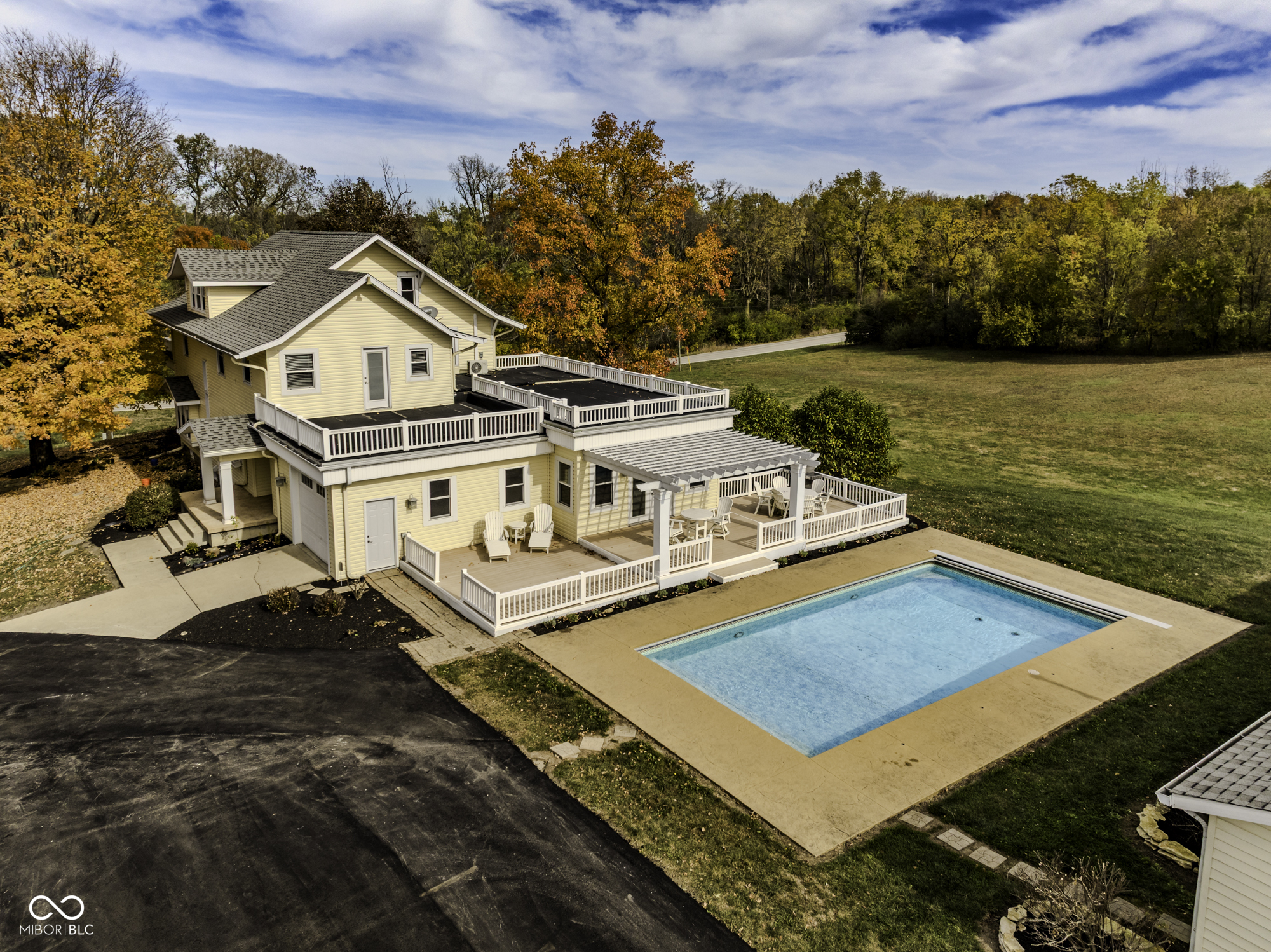 This spacious, three-story traditional home welcomes you through the front door, off a beautiful front porch with new ceiling fans, into a charming living room with built-in cabinetry. A great room offers a piano window and pocket doors, leading to a large formal dining room with French doors. These doors open to a spacious family room, complete with a gas log fireplace and French doors leading to the deck area and inground pool. The large eat-in kitchen is a chef's delight, featuring a generous center island with a breakfast bar, beautiful cherry cabinets, and solid-surface countertops. This floor also includes a den, utility area, and a newly remodeled full bathroom.  The second floor offers four bedrooms, including a master suite with a large, newly remodeled master bath featuring a double vanity, soaking tub, and stand-up shower, plus a great walk-in closet. An additional newly remodeled bathroom is also located on this floor. The third floor provides a large bedroom with a new mini-split system for heating and air.  Recent updates enhance the property's appeal, including a new roof (including a rubber roof)  just three weeks old, a newer firepit, and a newer dock. A 125-gallon buried propane tank  serves the fireplace and a gas grill on the deck by the swimming pool. In addition, the property offers two separate four-car detached garages. This is a must-see property, as its beauty from front to back is beyond imagination!